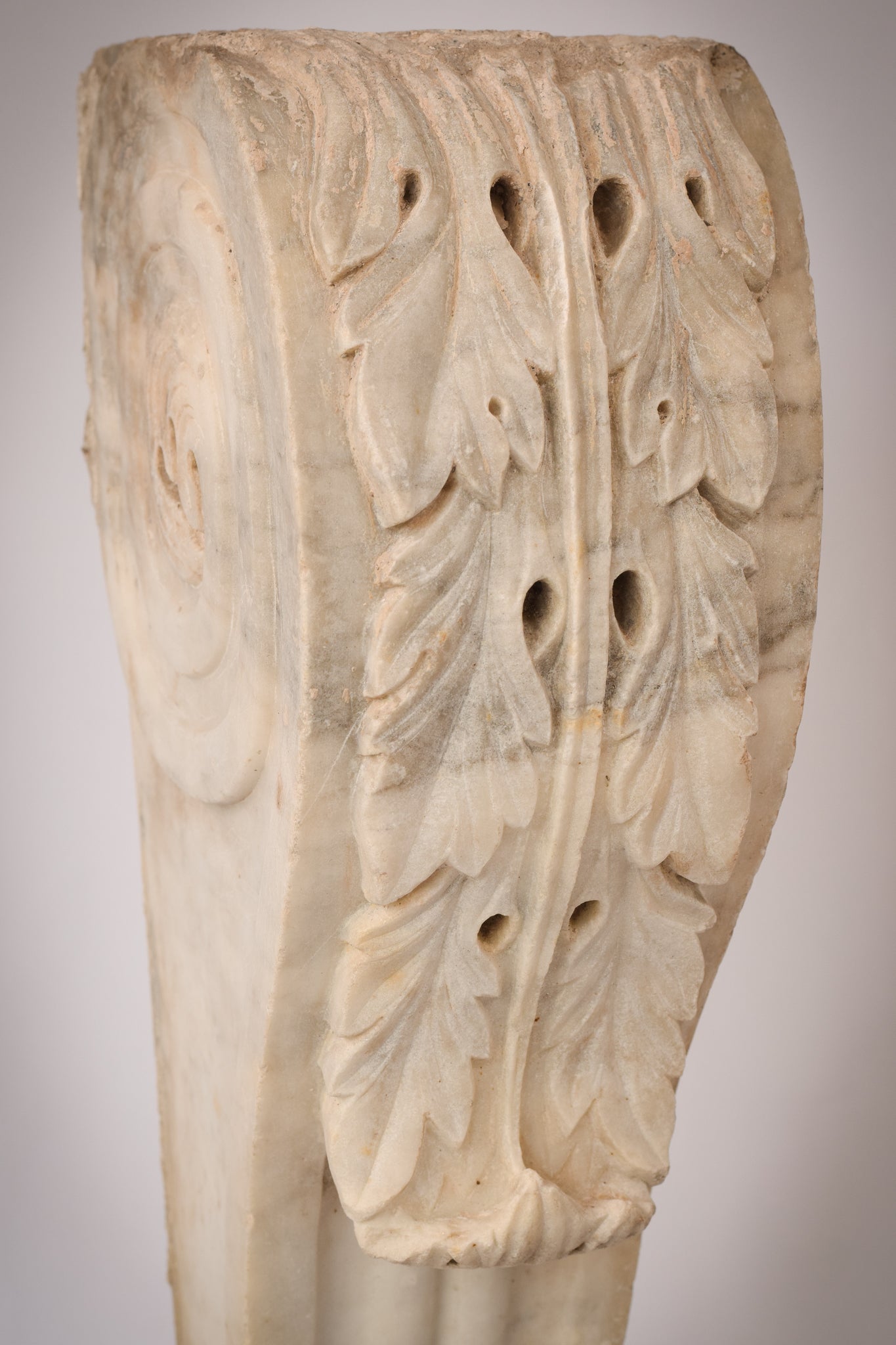A white marble column with a leaf design on it.