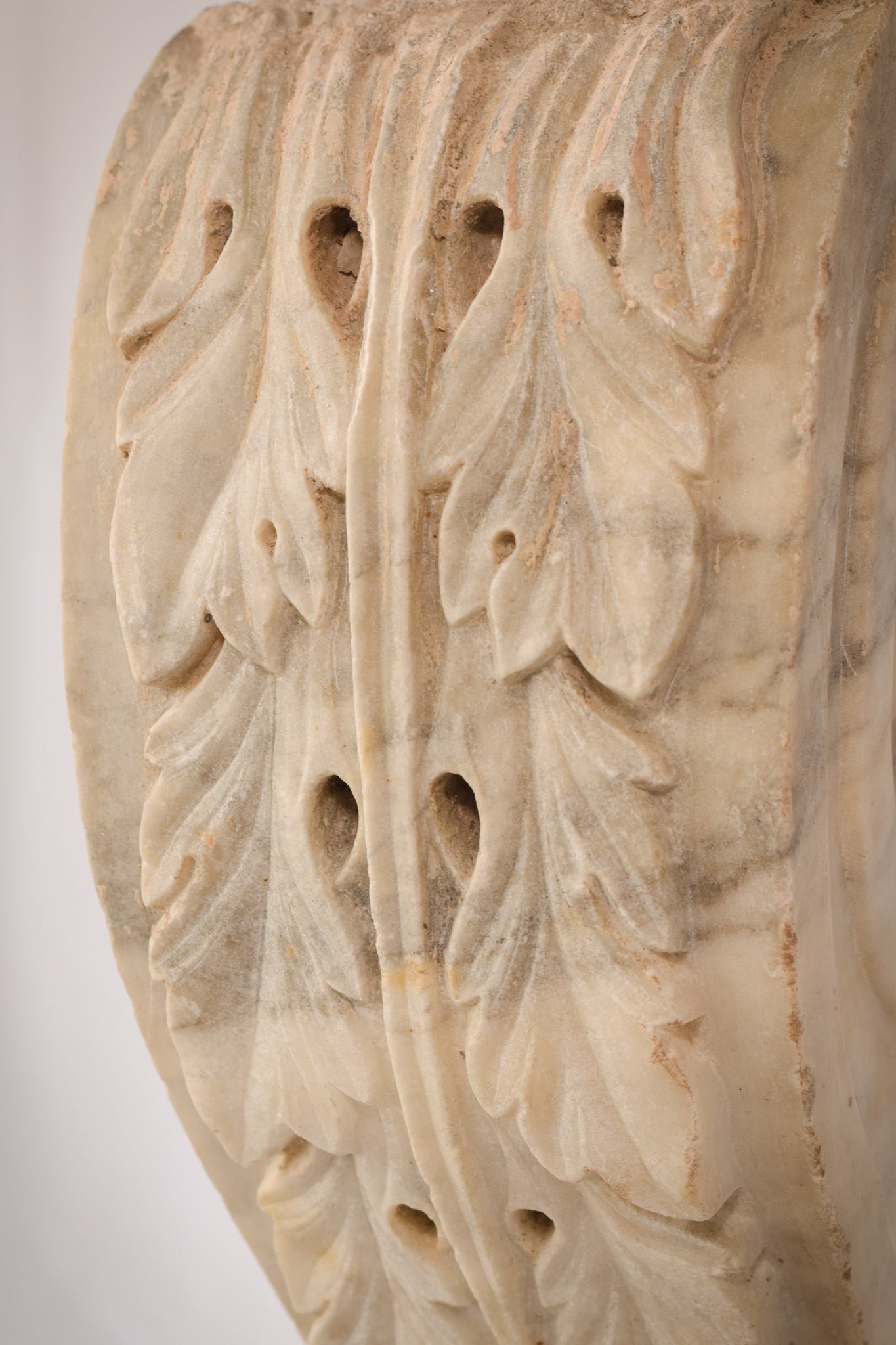 A white marble column with a leaf design on it.