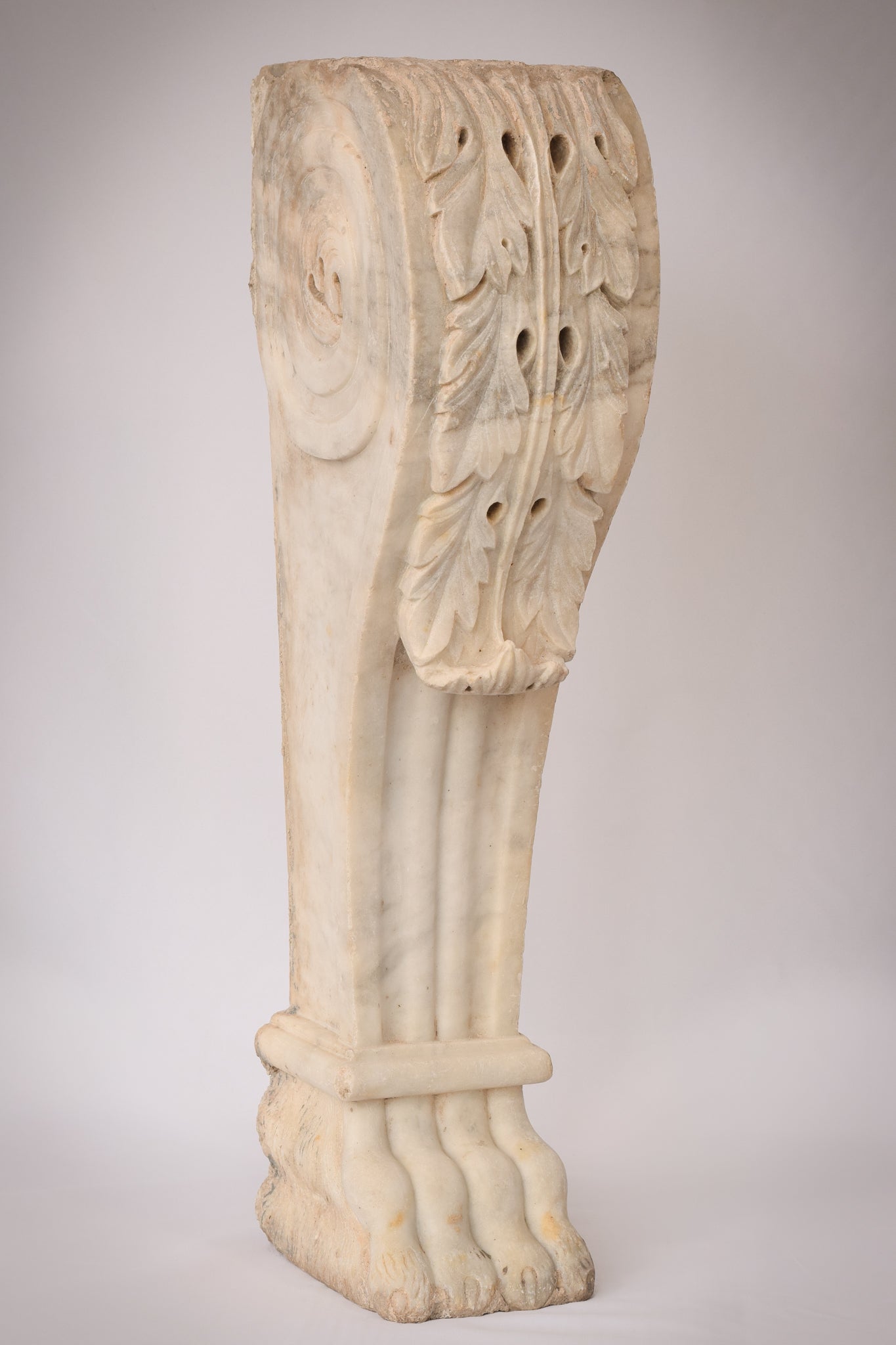 A white marble column with a leaf design on it.