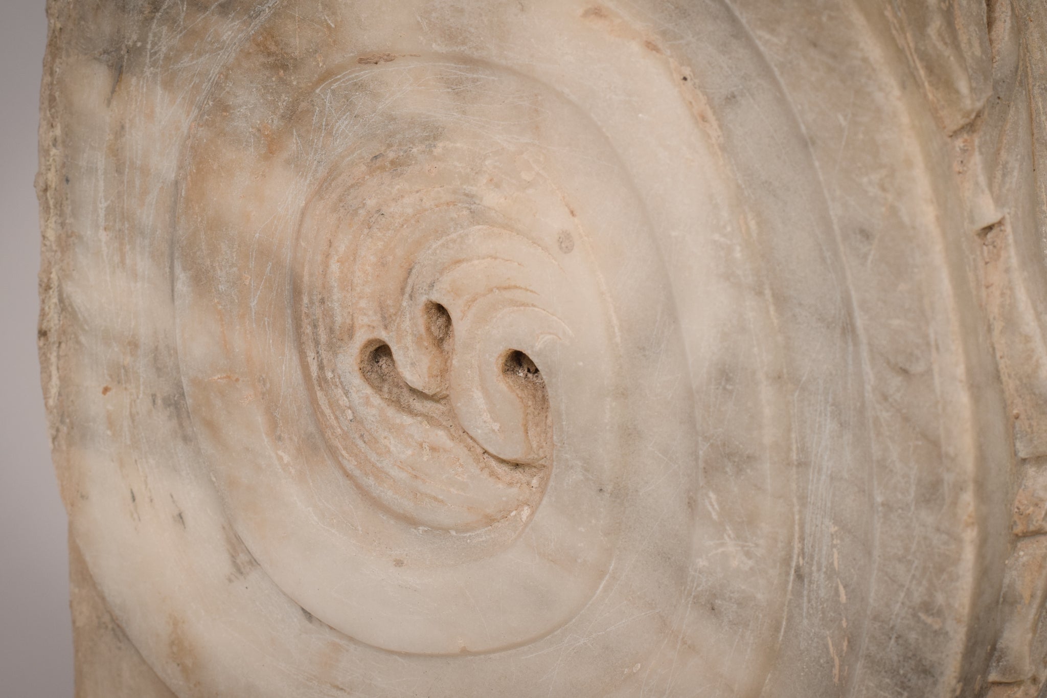 A white marble column with a leaf design on it.
