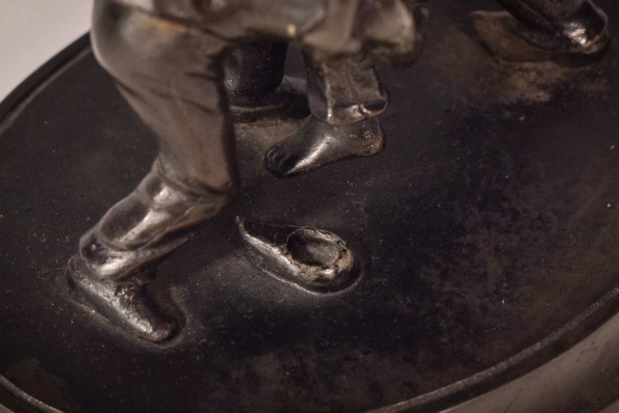 A bronze statue of two wrestlers wrestling on a metal base.