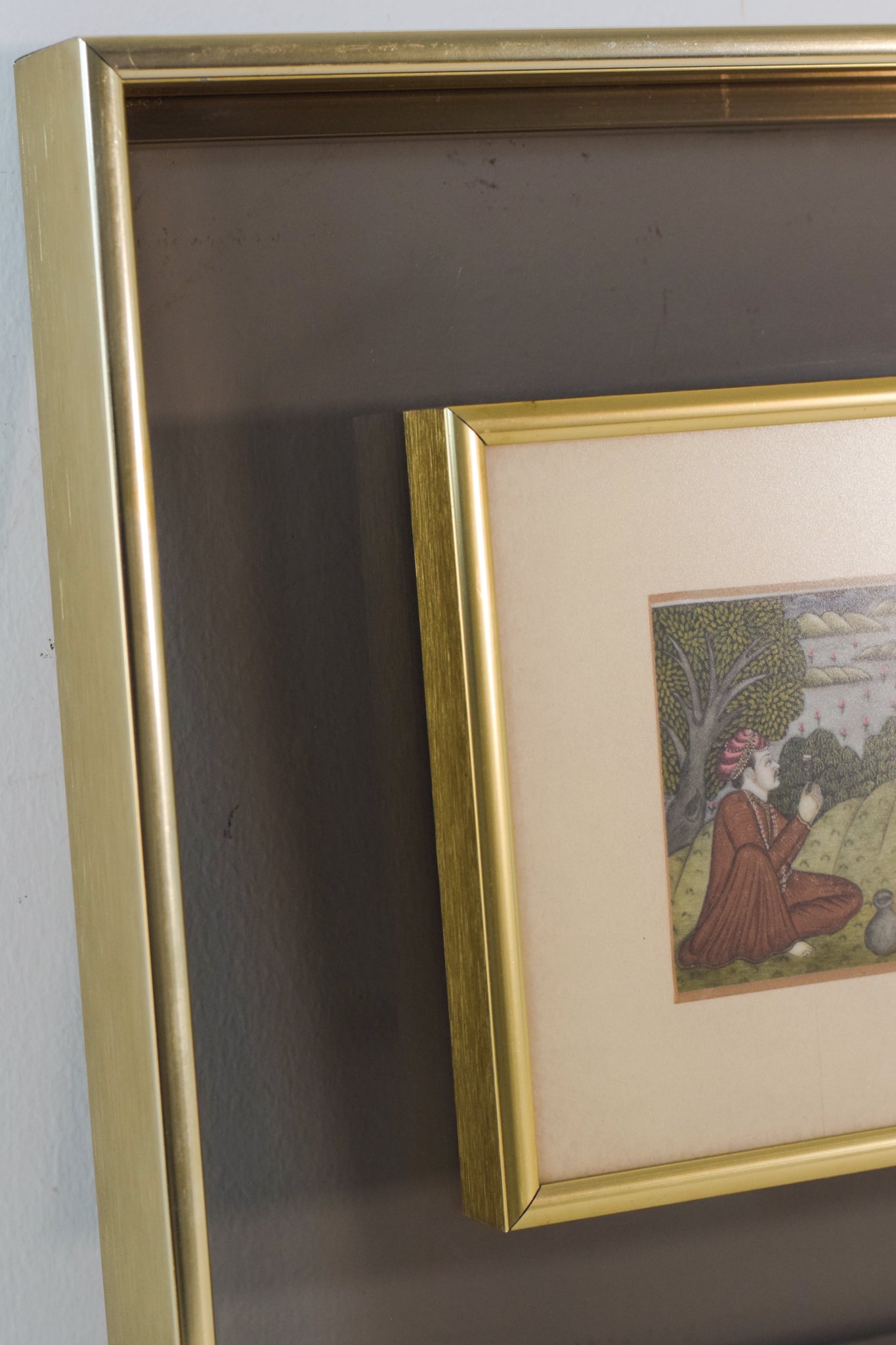 A painting of two men sitting on the ground in front of a house.