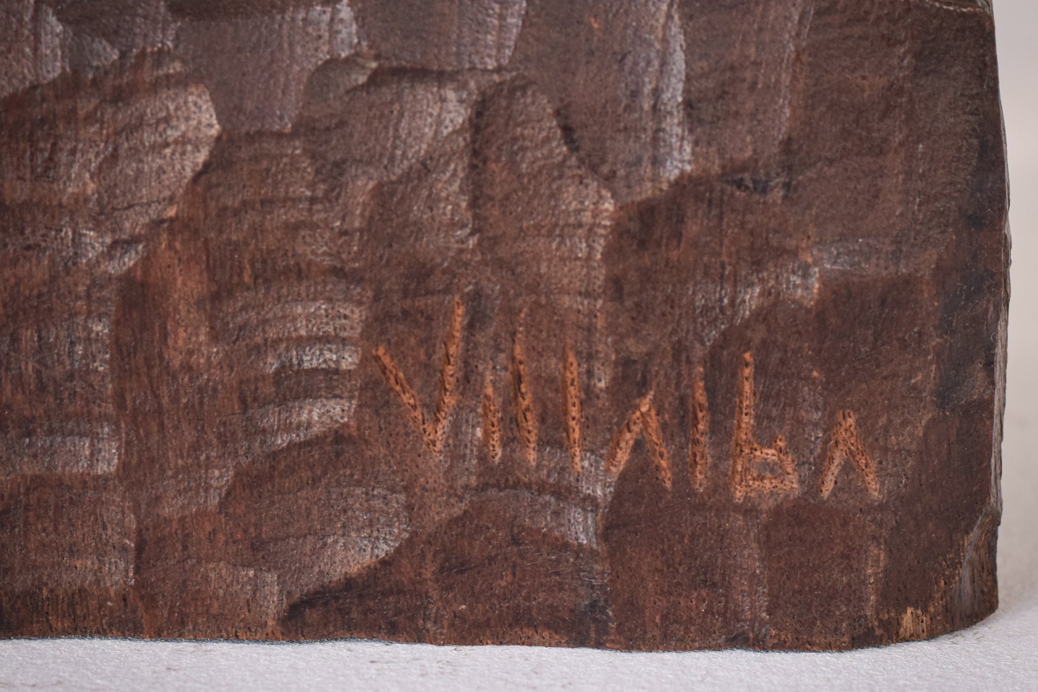 A wooden statue of a man with a cane and a hat.
