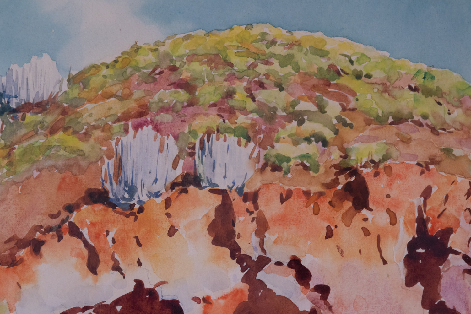 A watercolor painting of a rocky landscape with trees on a hillside.