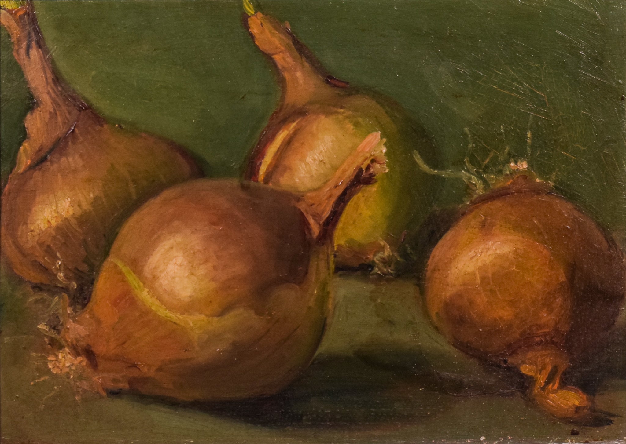 A painting of three onions on a green surface.