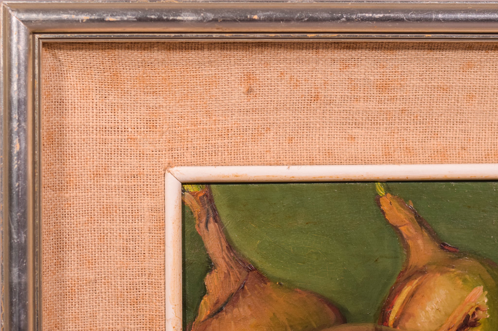 A painting of three onions on a green surface.