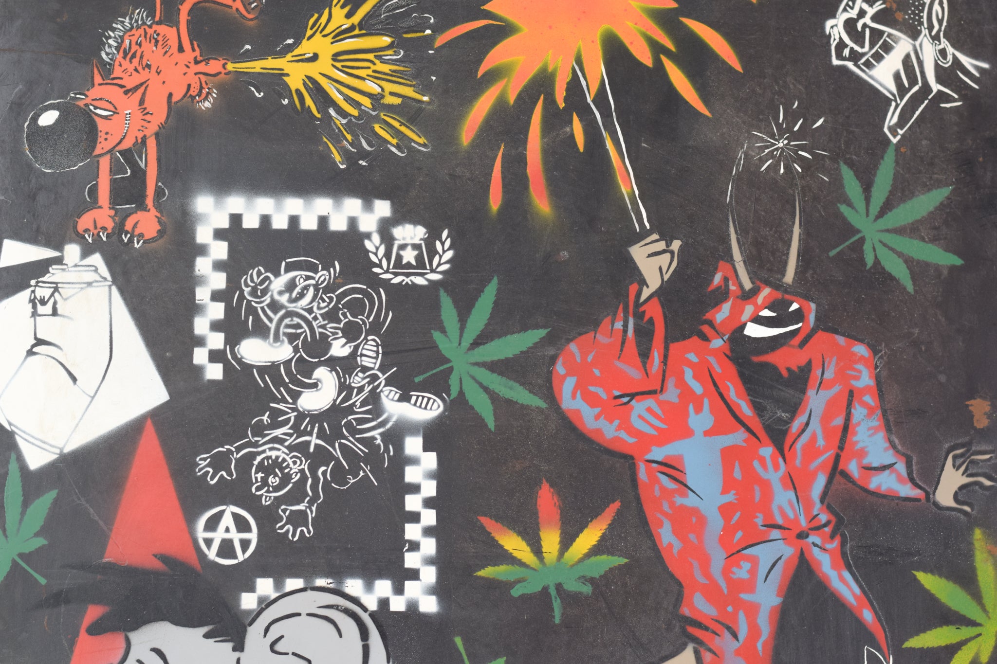 A wall covered in lots of different types of graffiti.