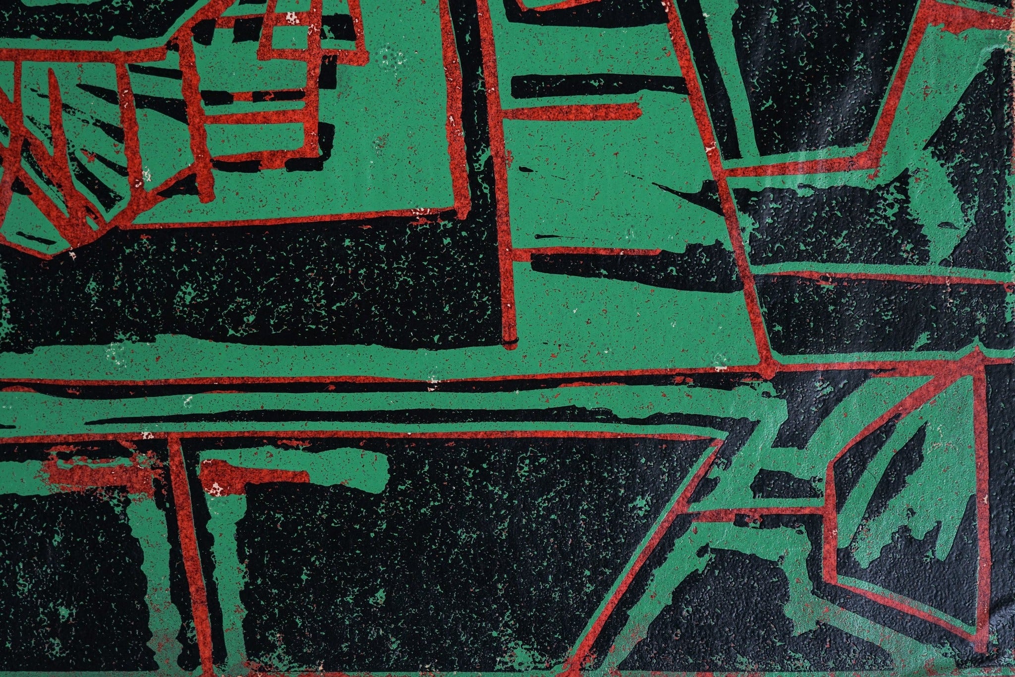 A painting of a green and red design on a black background.