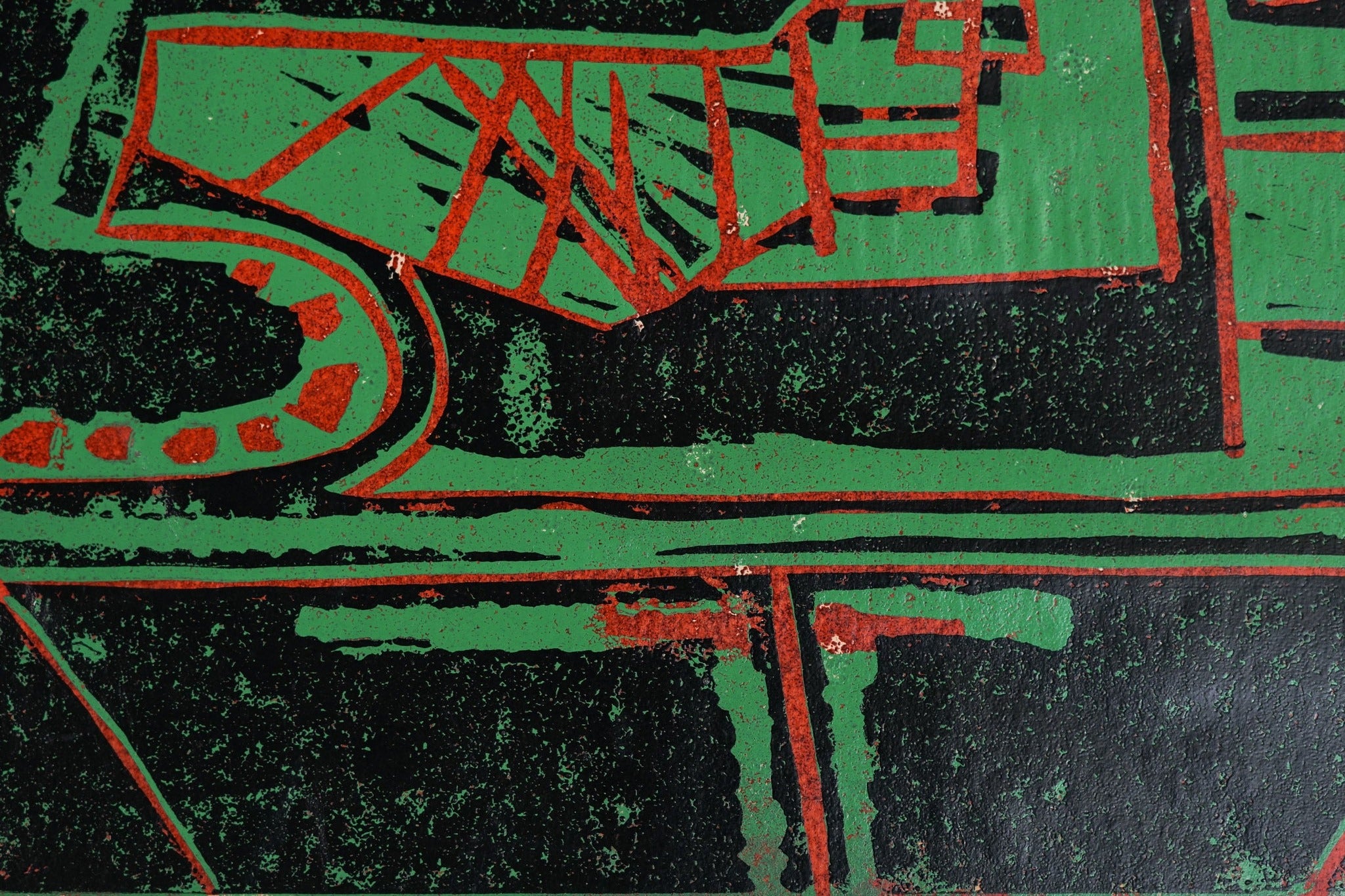 A painting of a green and red design on a black background.