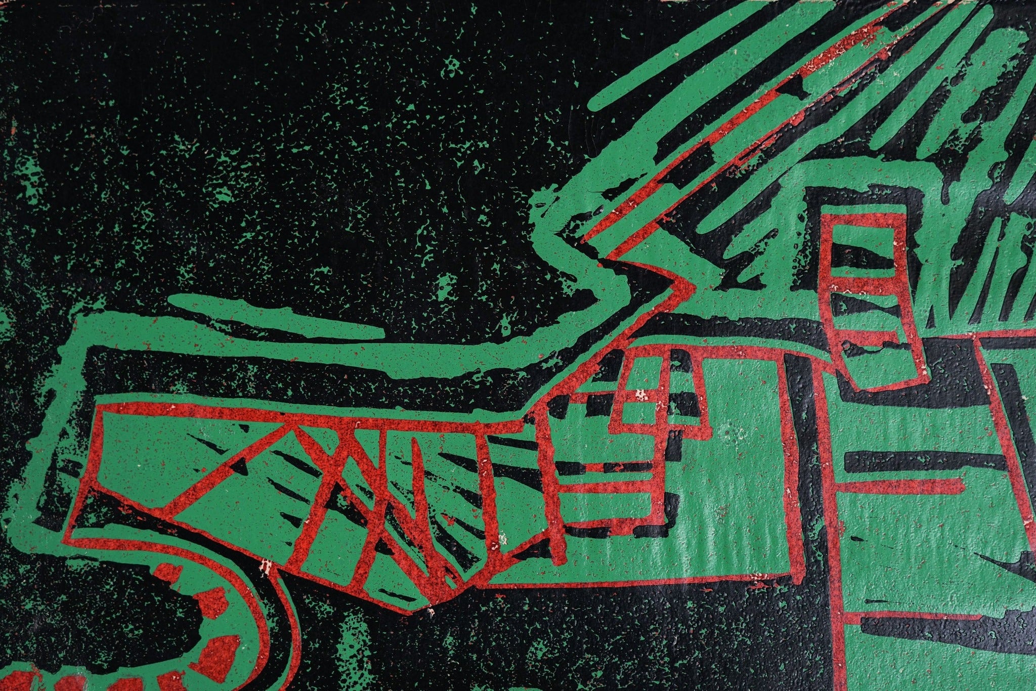 A painting of a green and red design on a black background.