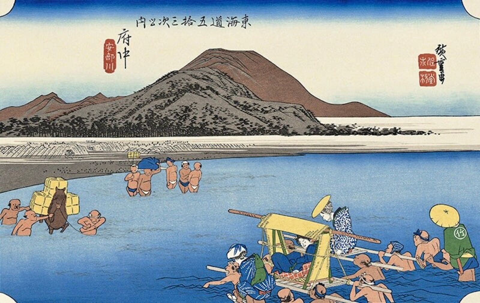 A group of people in a body of water near a mountain.
