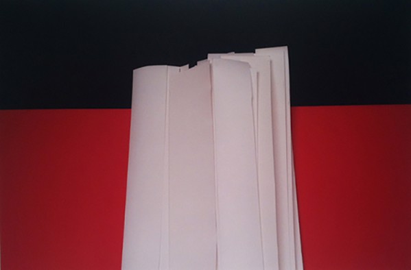 A stack of white paper on a red and black background.