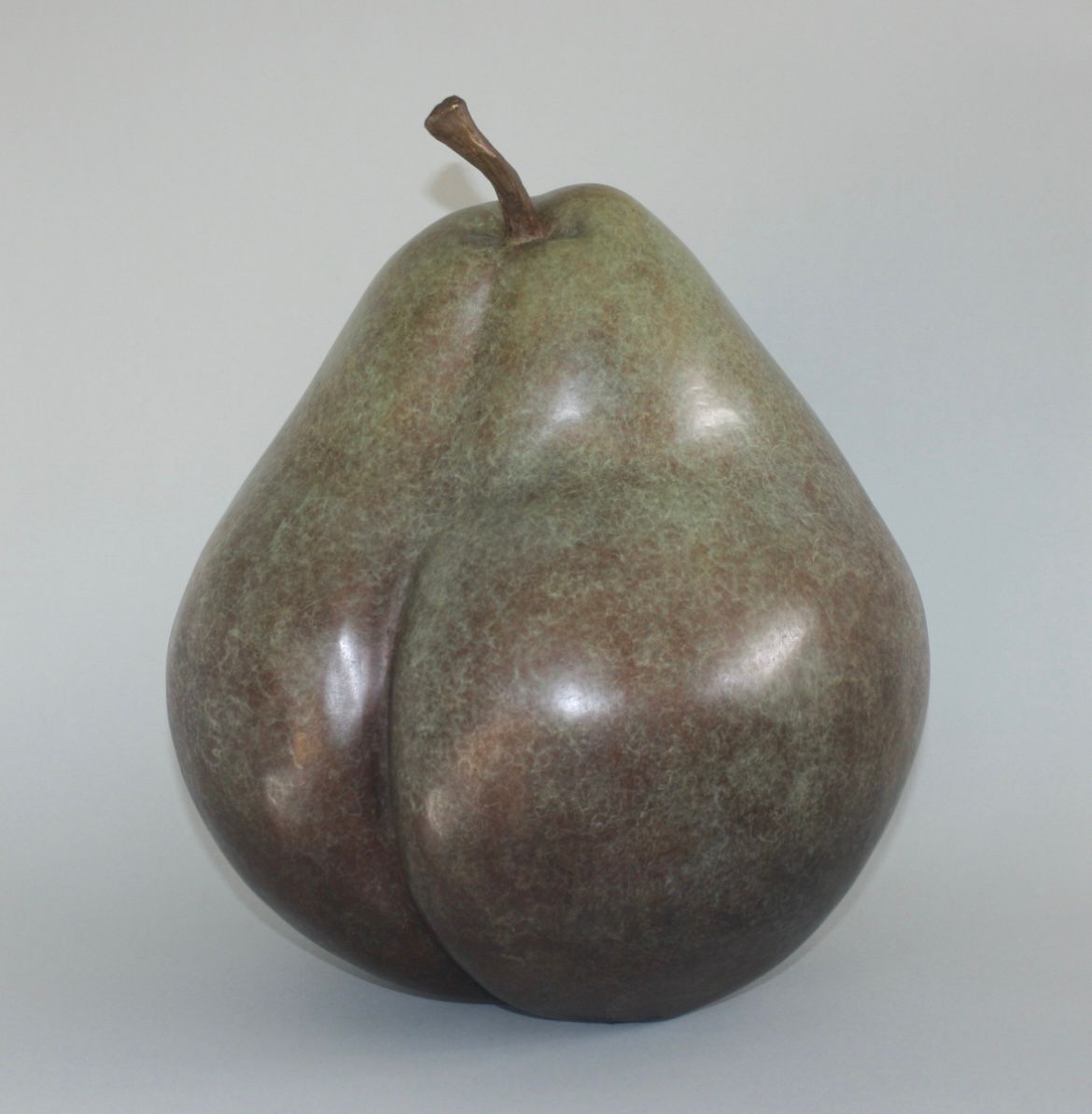 A large green pear sitting on top of a table.