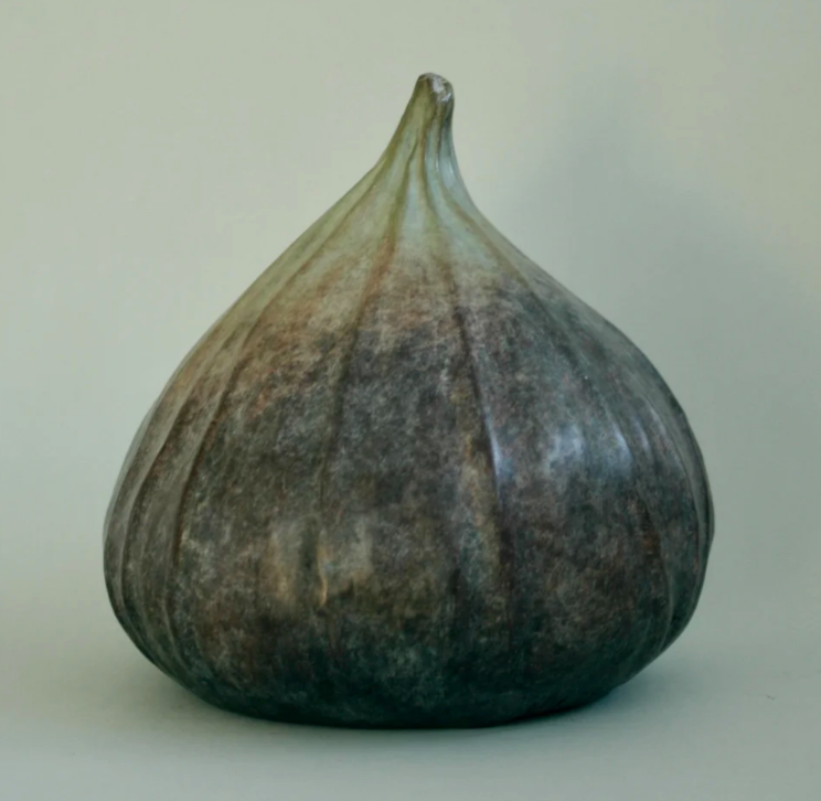 A ceramic sculpture shaped like a bulbous vegetable with a tapered stem, featuring a mottled dark glaze.