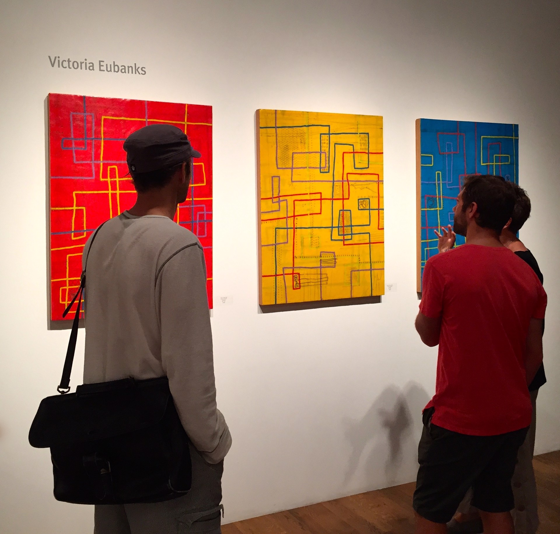 A tripartite abstract composition featuring a grid of geometric shapes and lines across three distinct color fields.