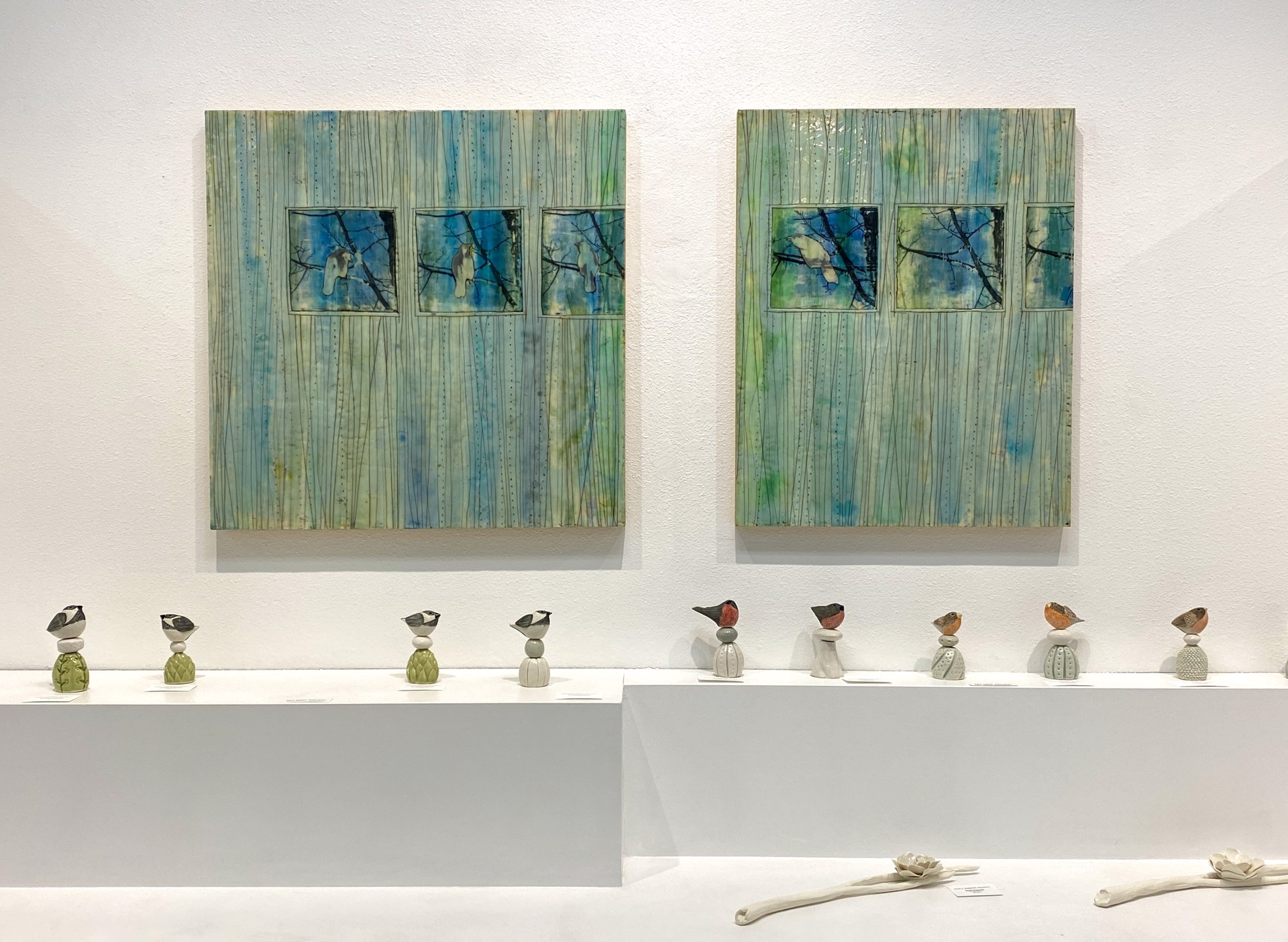 A mixed-media artwork featuring three framed birds perched on branches against a textured, vertical-lined background.