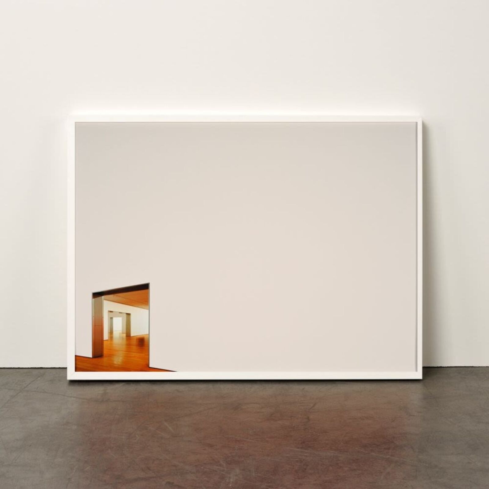 A minimalist framed photograph featuring a stark white wall with a small, colorful opening revealing an interior space.