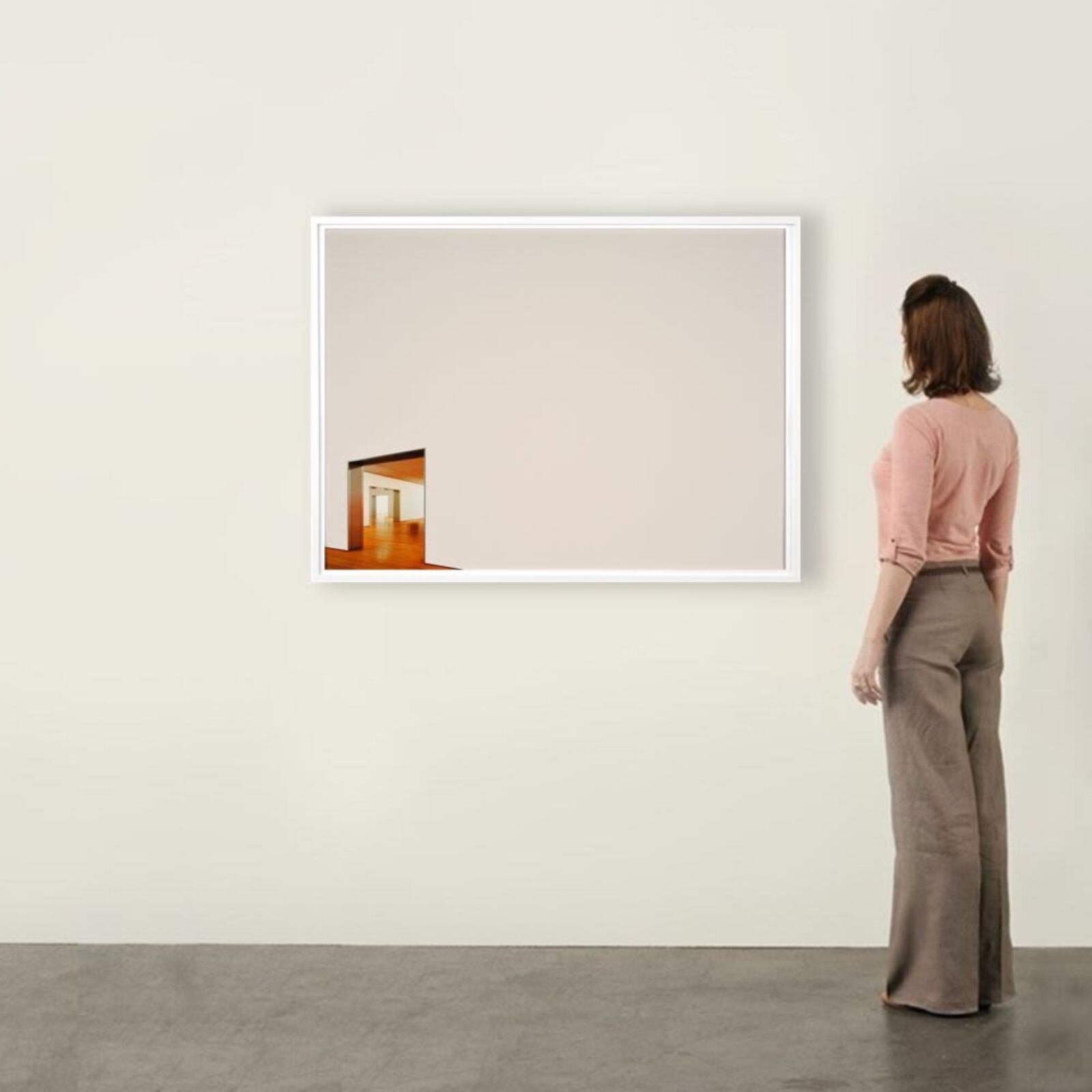A minimalist framed photograph featuring a stark white wall with a small, colorful opening revealing an interior space.
