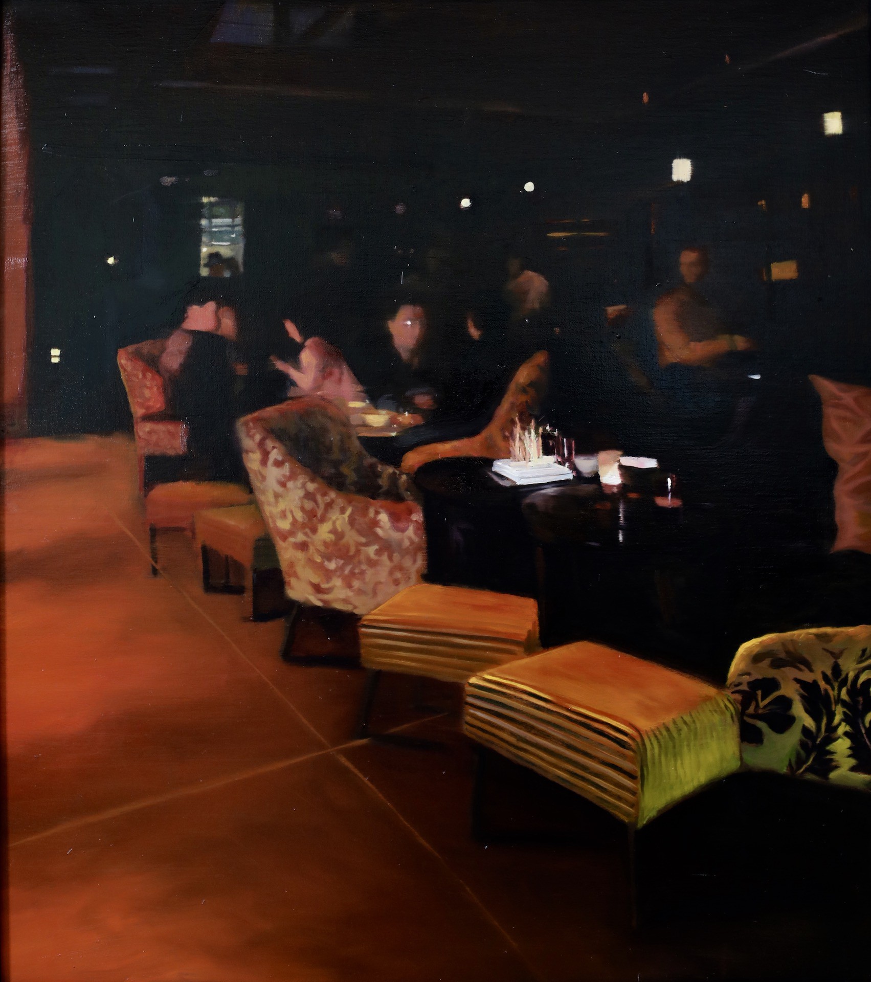 A moody, dimly lit interior scene featuring patterned armchairs and striped ottomans in a lounge setting.