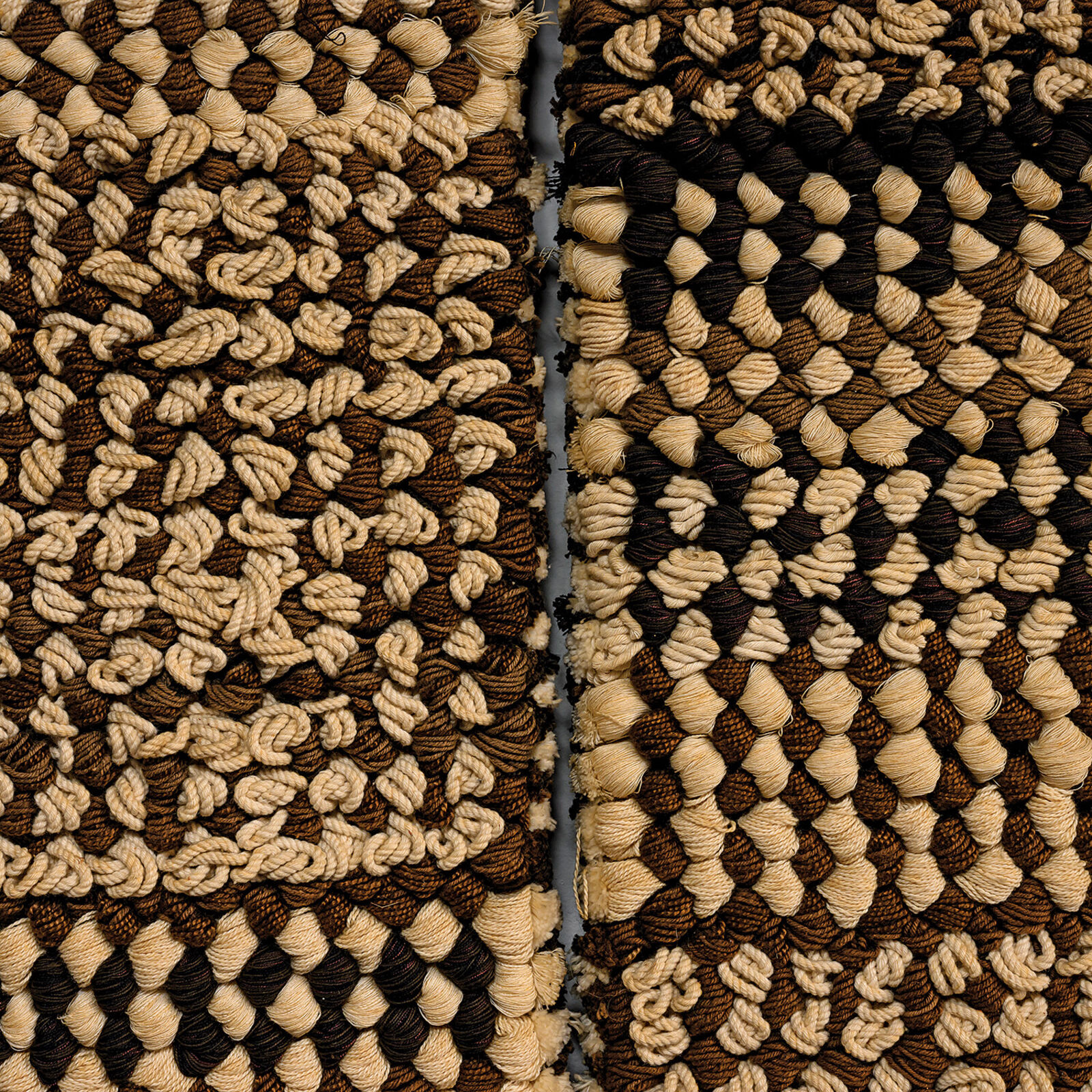 A woven textile artwork featuring a grid of textured squares in earthy tones.