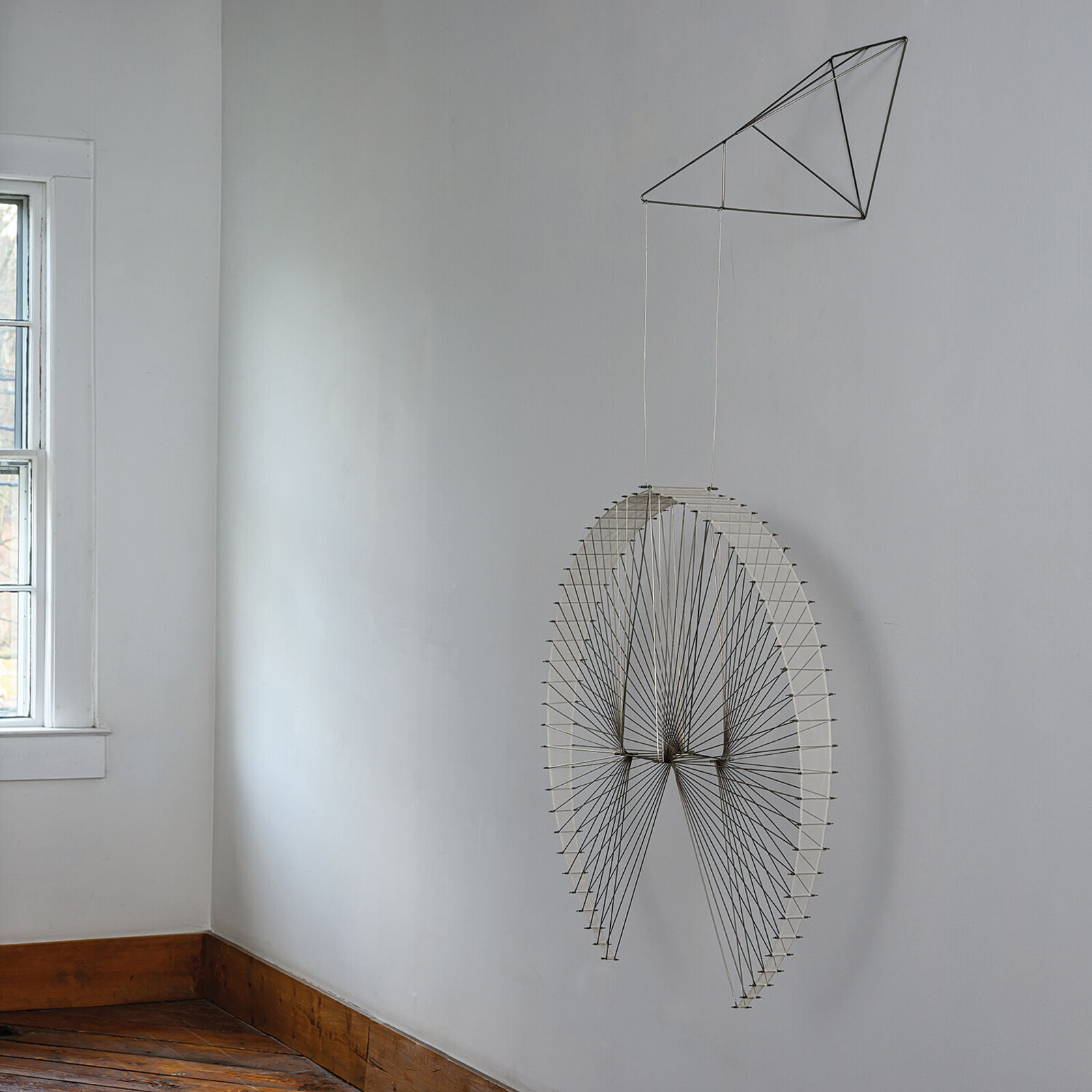 A large metal sculpture hanging from the ceiling in a room.
