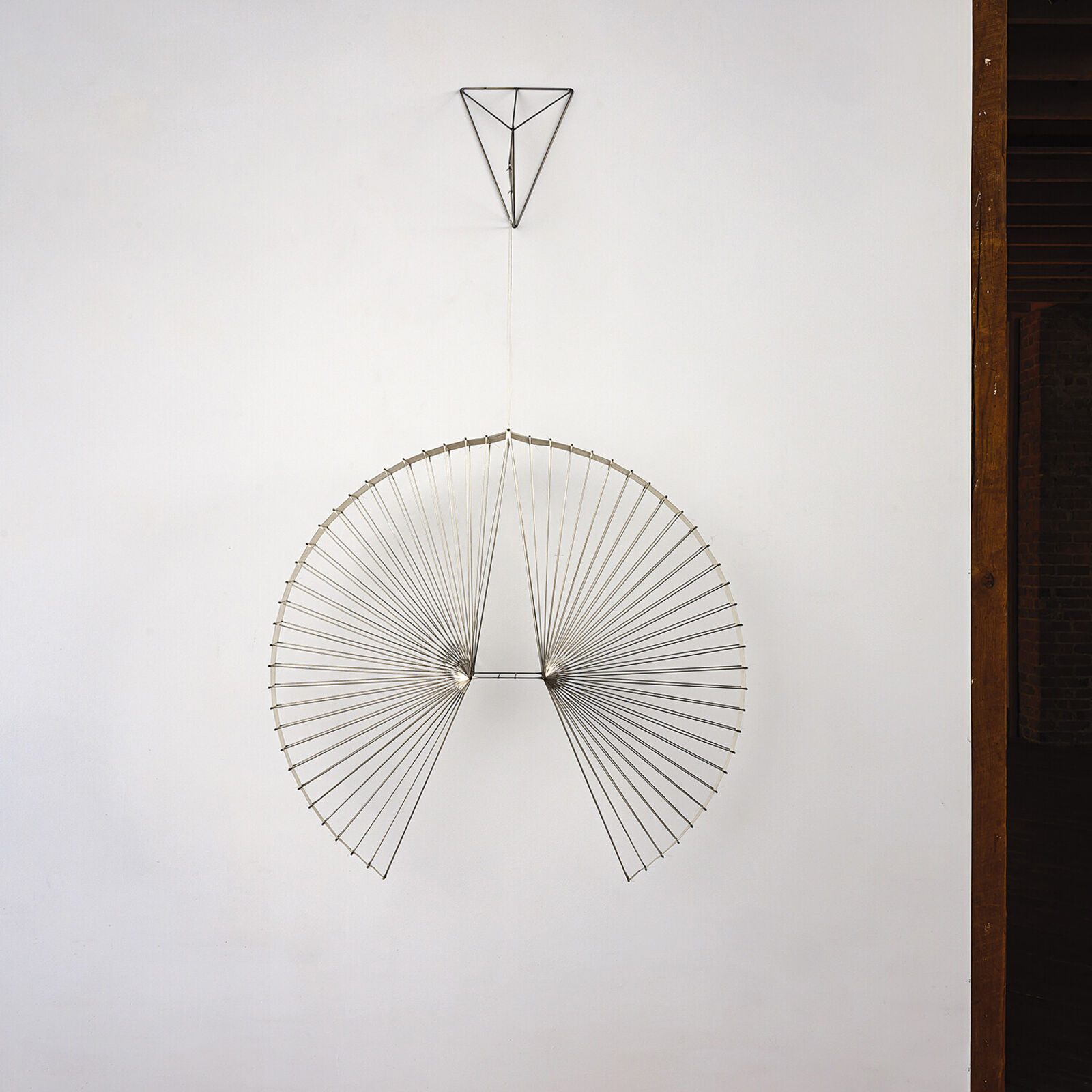 A large metal sculpture hanging from the ceiling in a room.