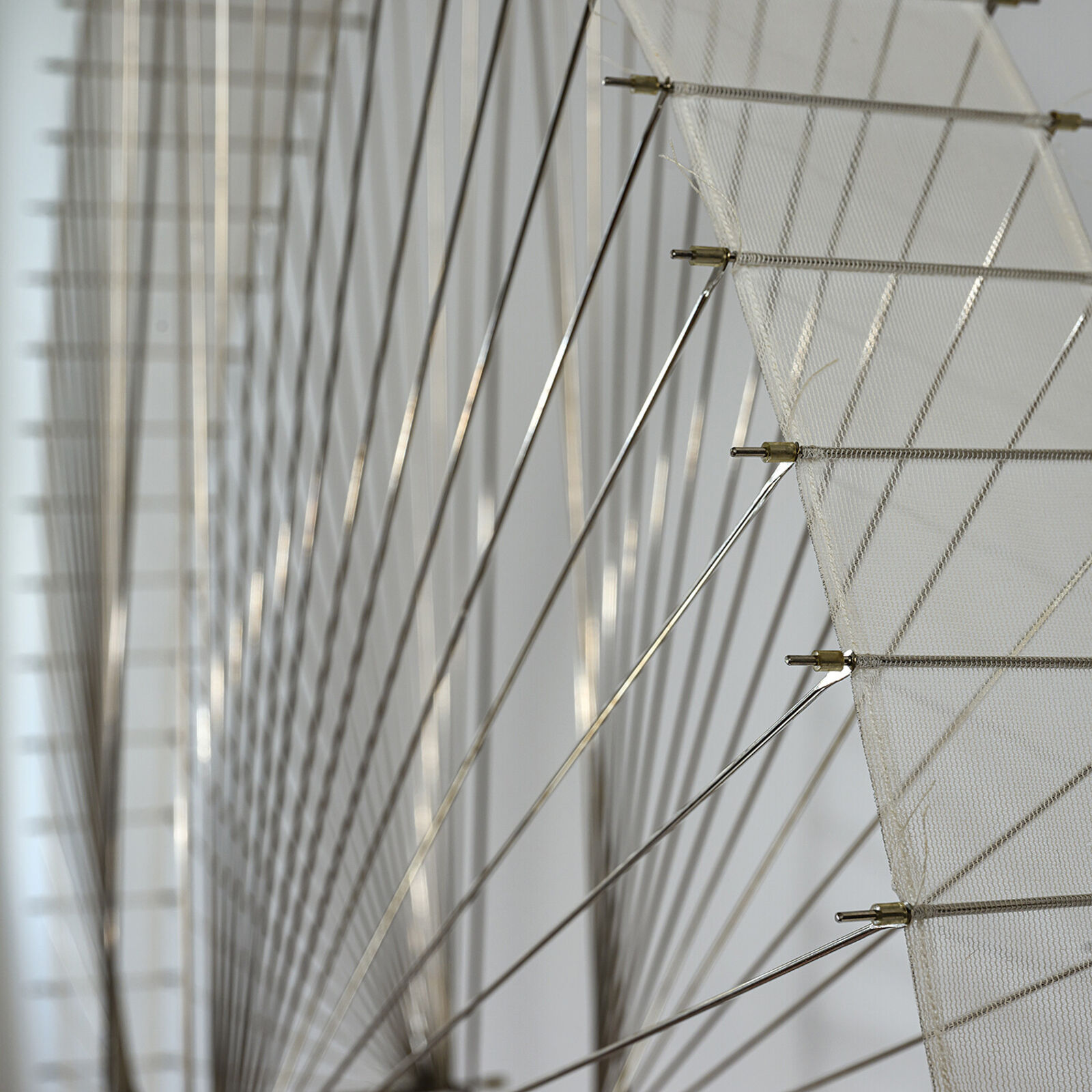 A large metal sculpture hanging from the ceiling in a room.