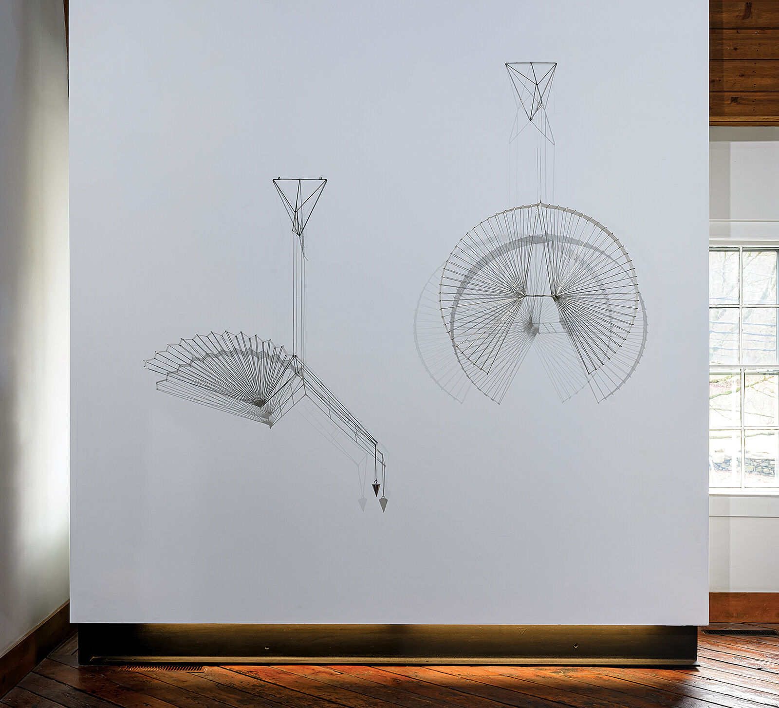 A large metal sculpture hanging from the ceiling in a room.