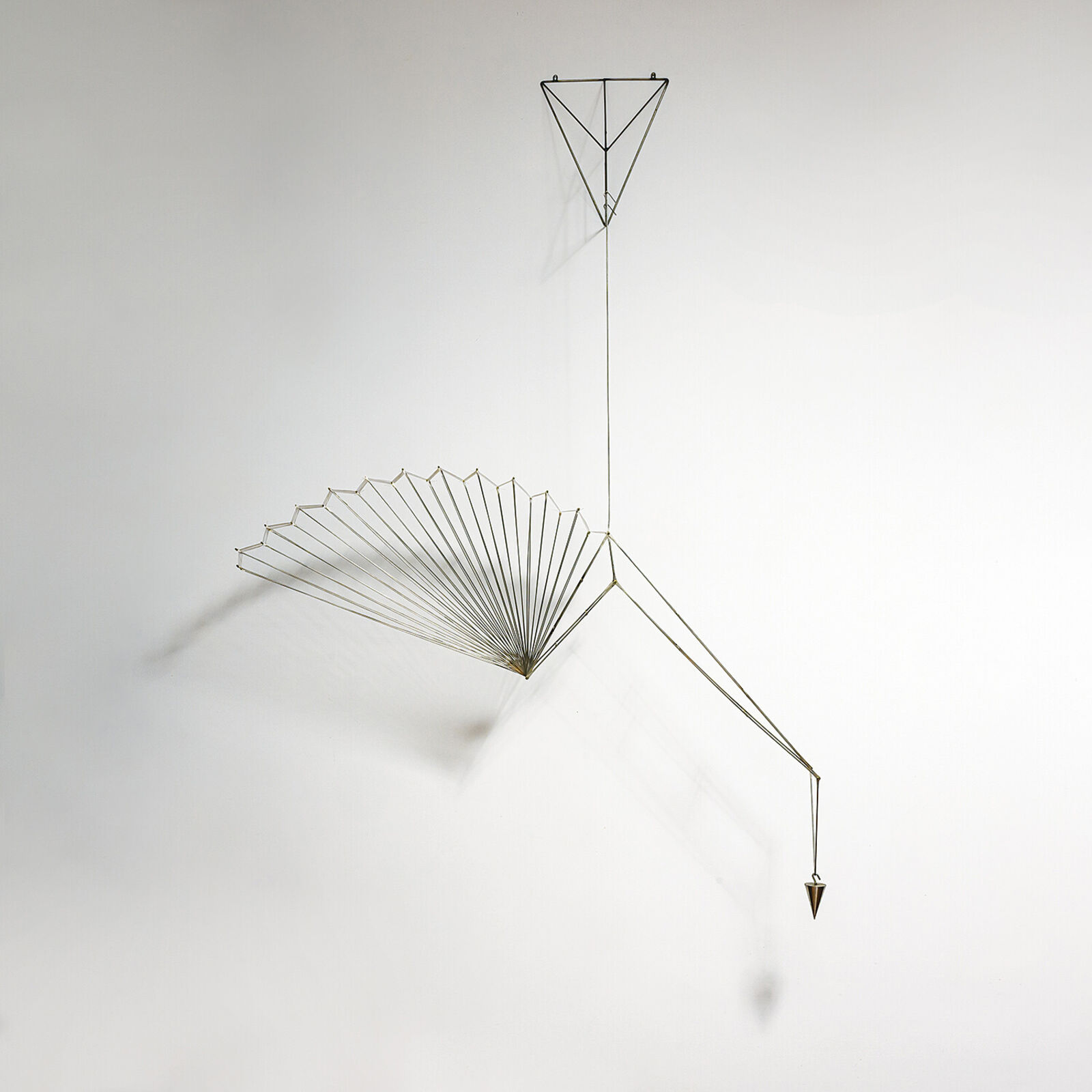 A metal sculpture of a bird hanging from a string.