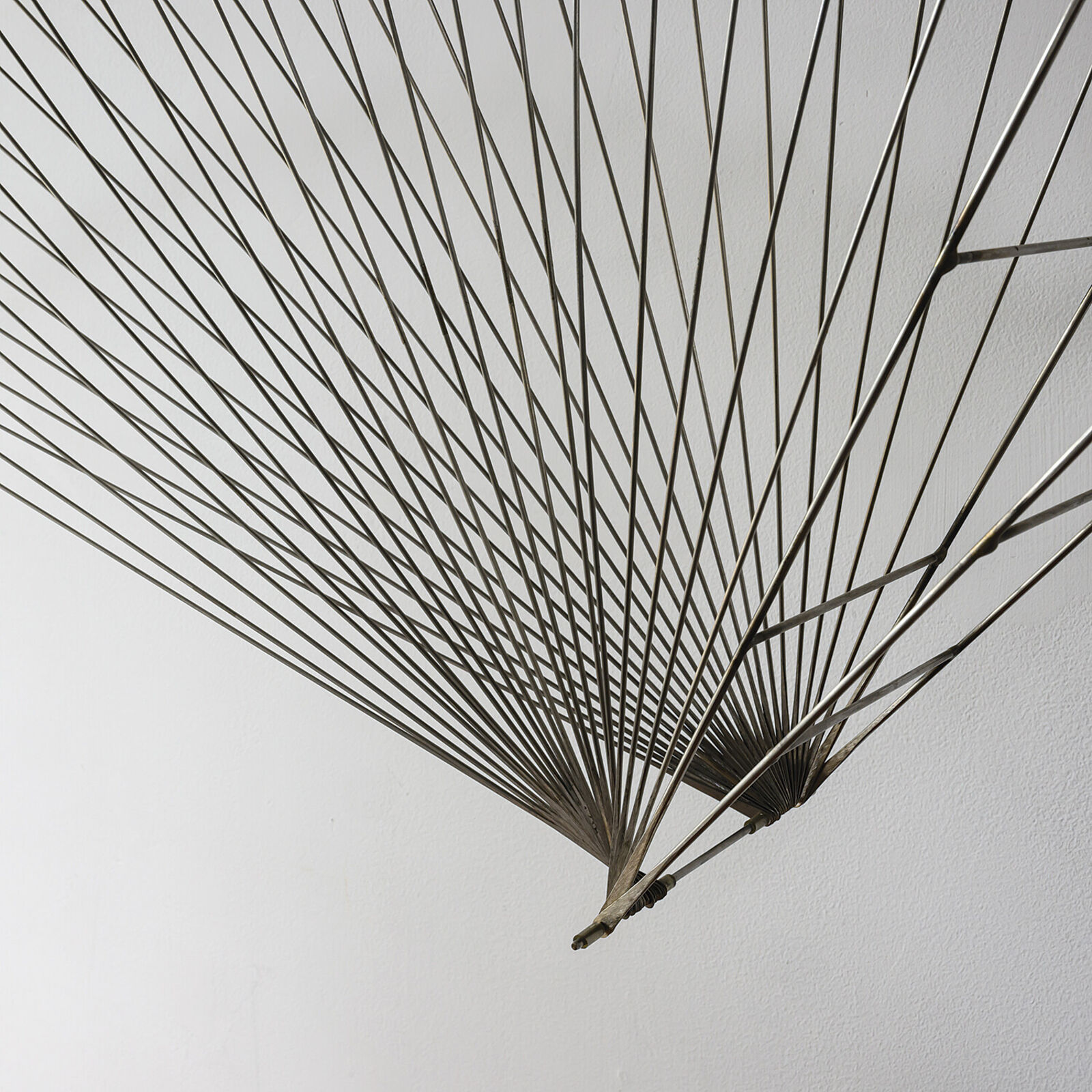 A metal sculpture of a bird hanging from a string.