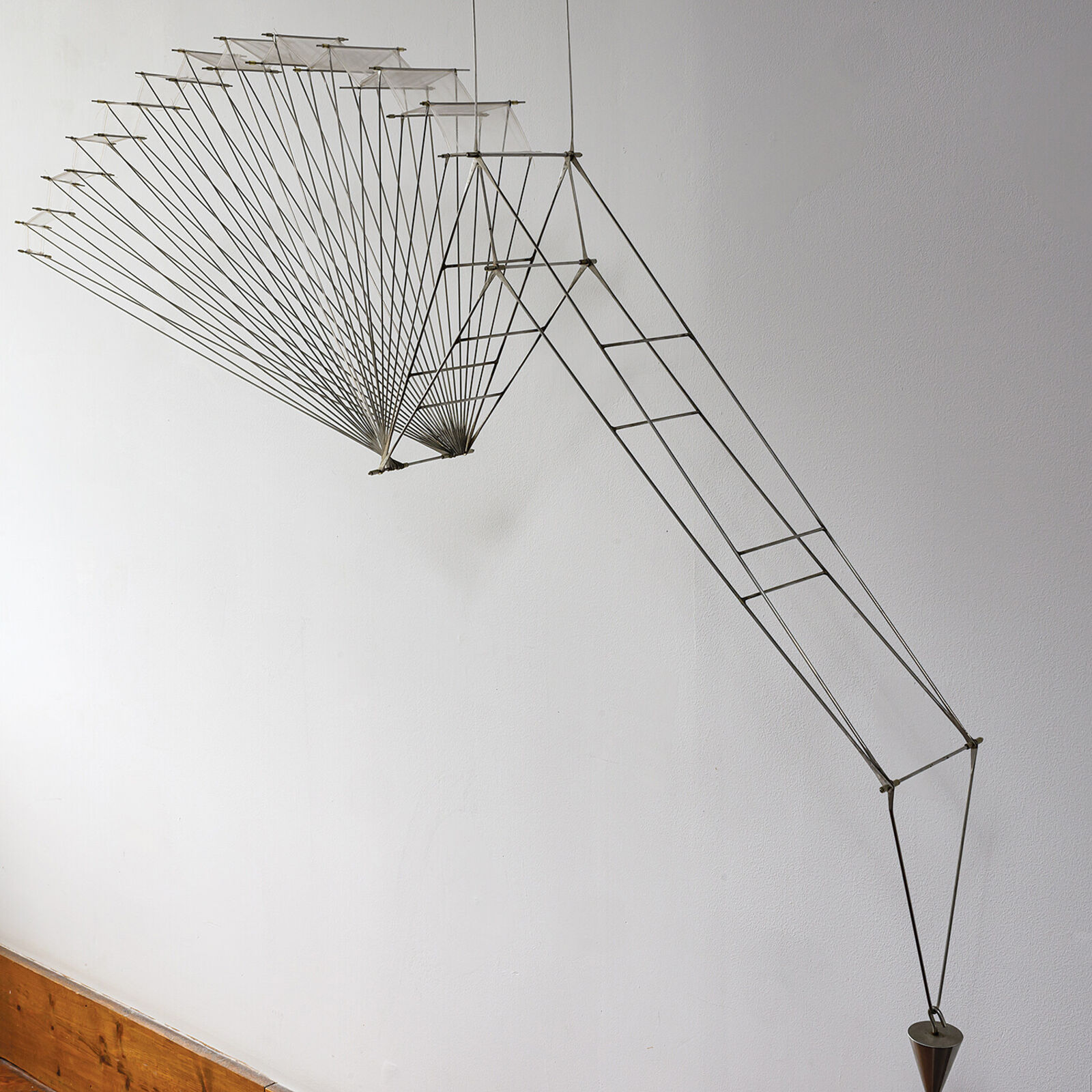 A metal sculpture of a bird hanging from a string.