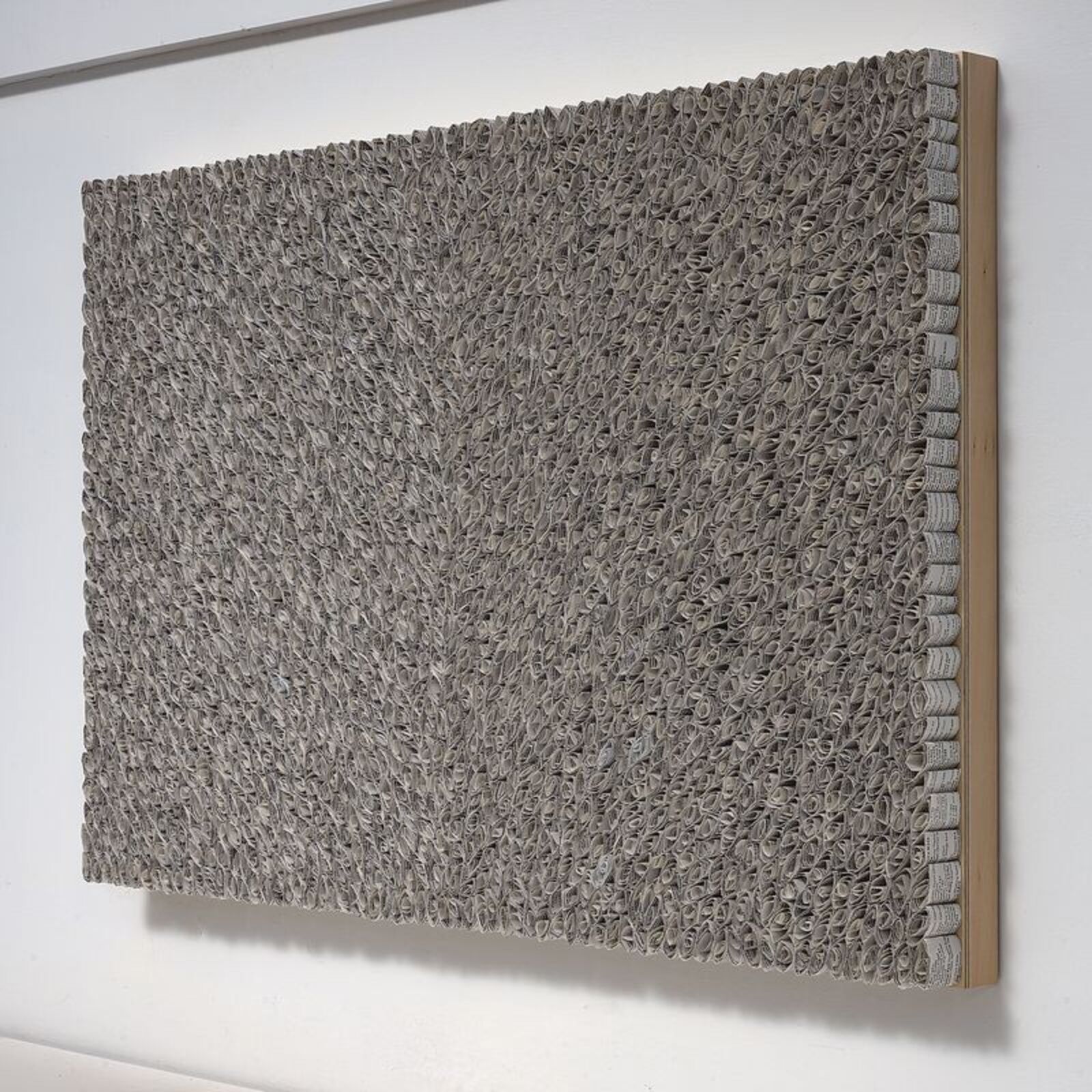 A black and white painting hanging on a wall next to a window.