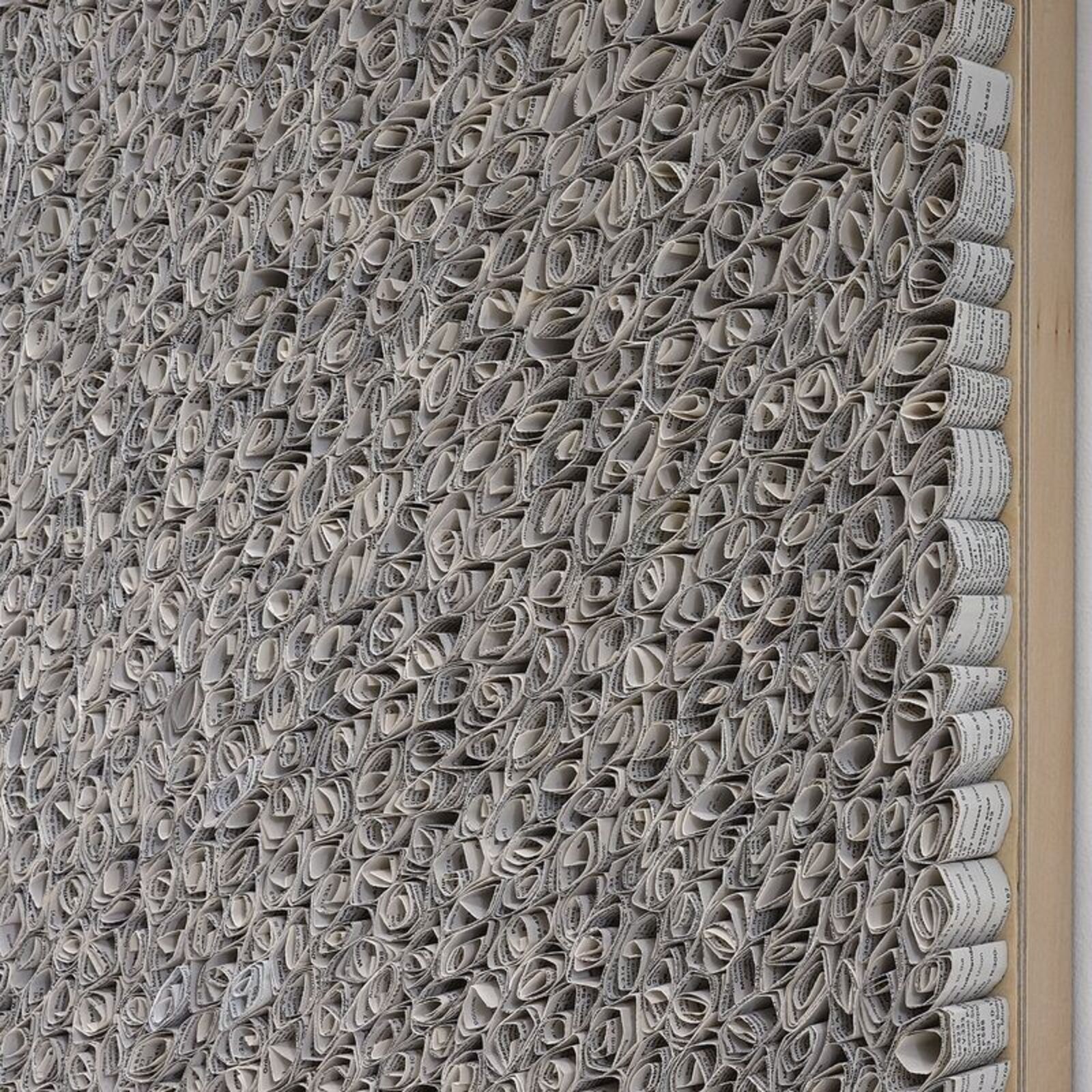 A black and white painting hanging on a wall next to a window.