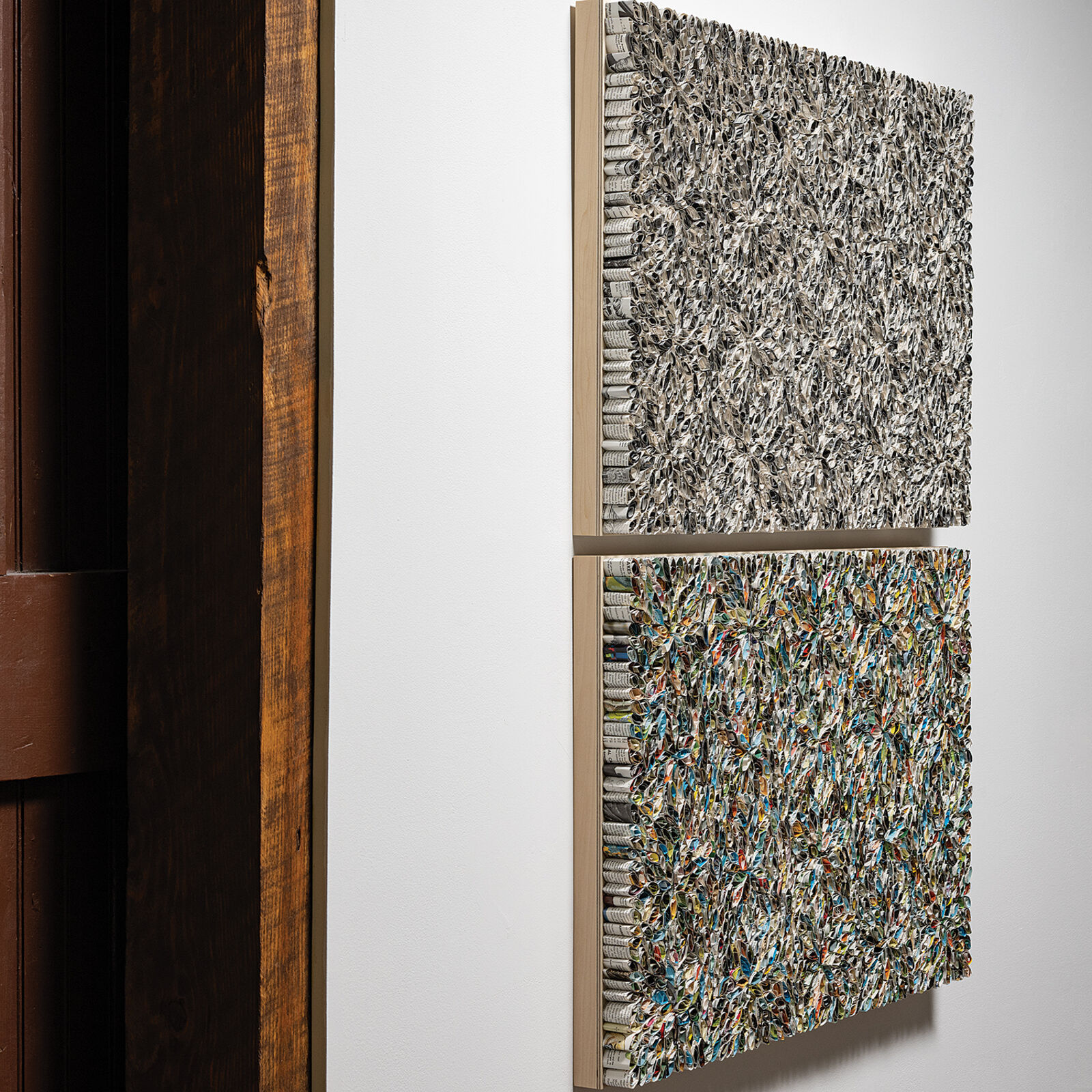 A diptych of textured, floral-patterned panels mounted on a white wall.