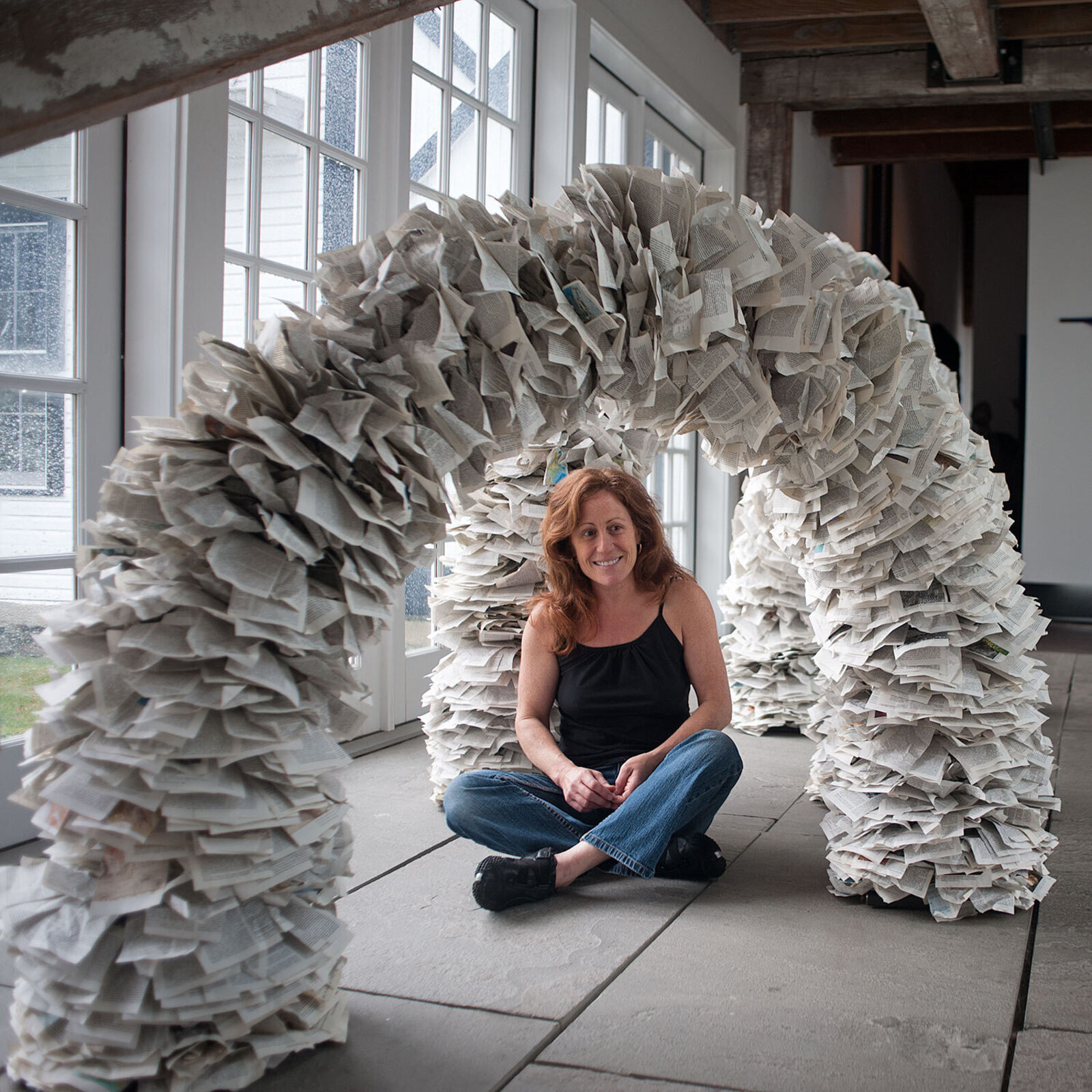 A sculptural archway constructed from thousands of layered paper pages.