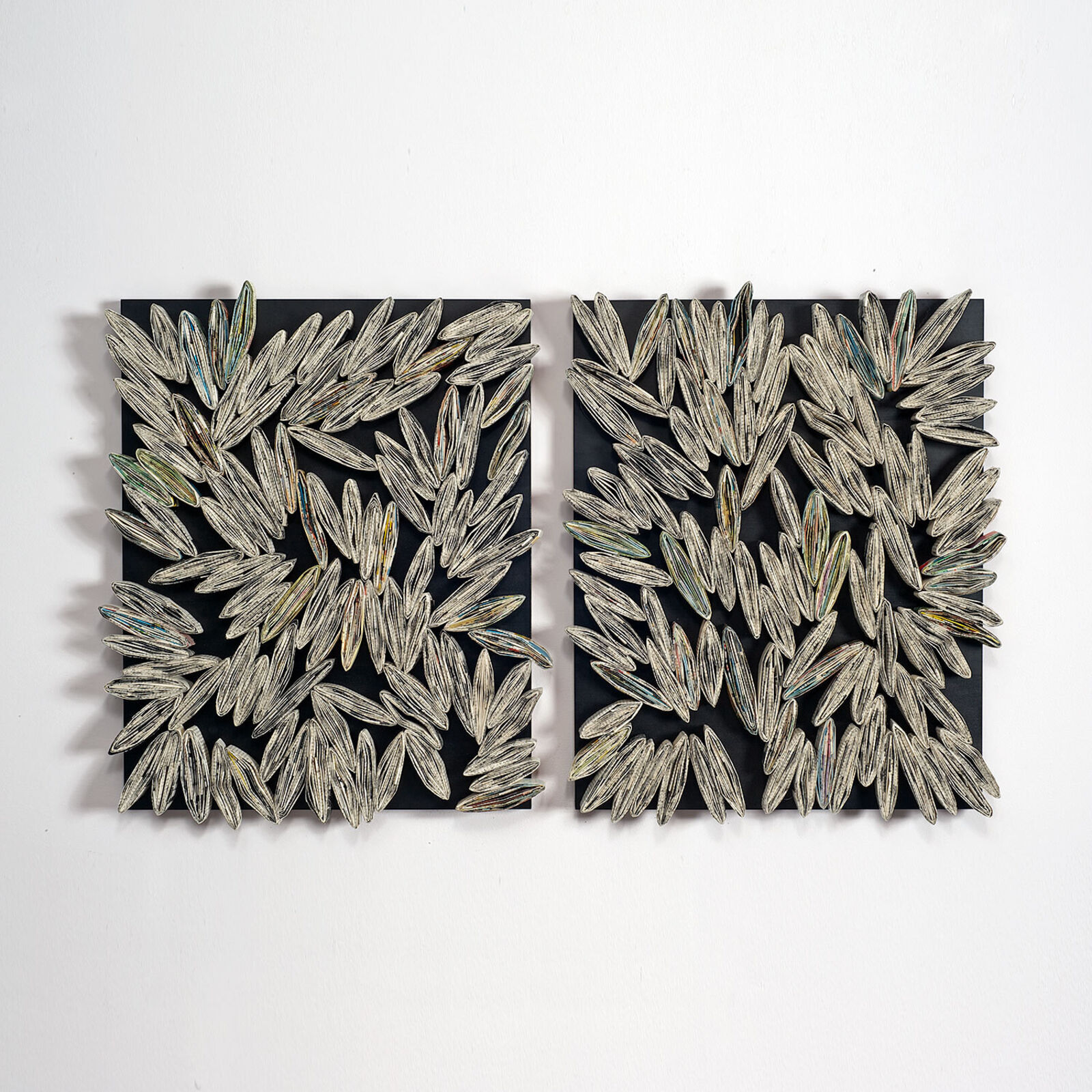 A pair of black and white wall art on a white wall.