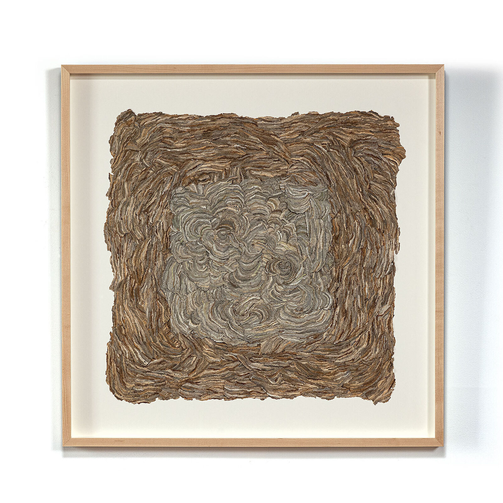 A framed square artwork featuring a textured, swirled surface in earthy tones.