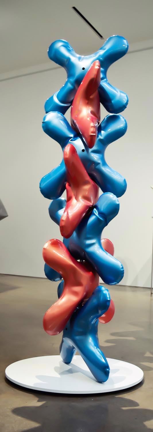 a blue and red sculpture on a white pedestal in a room