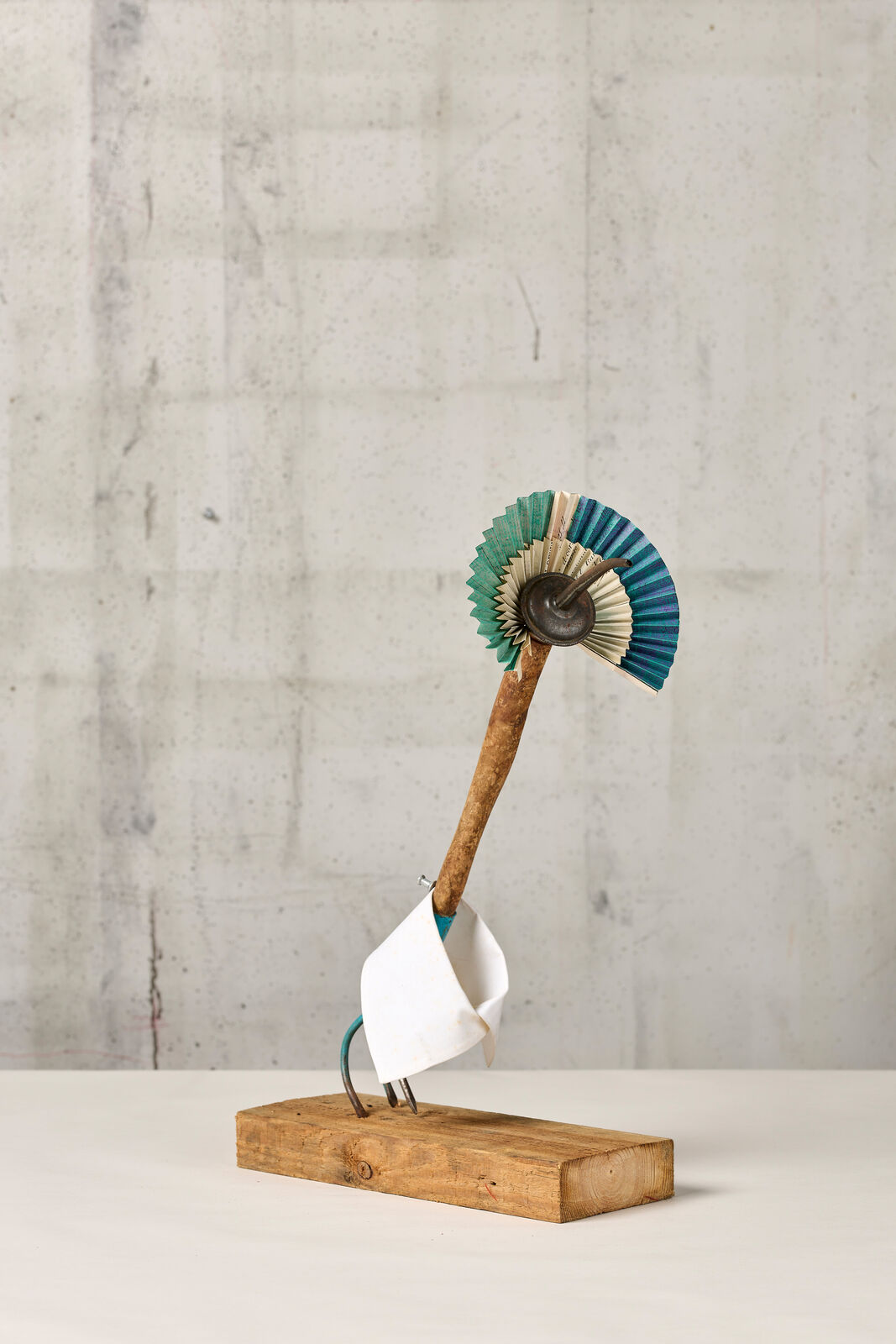 A wooden stick with a blue and white fan on top of it.