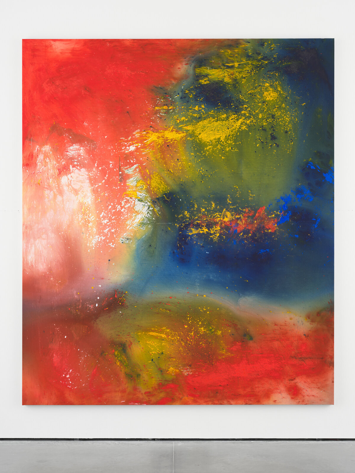 A vibrant abstract painting featuring bold reds, blues, and yellows with a dynamic, splattered texture.