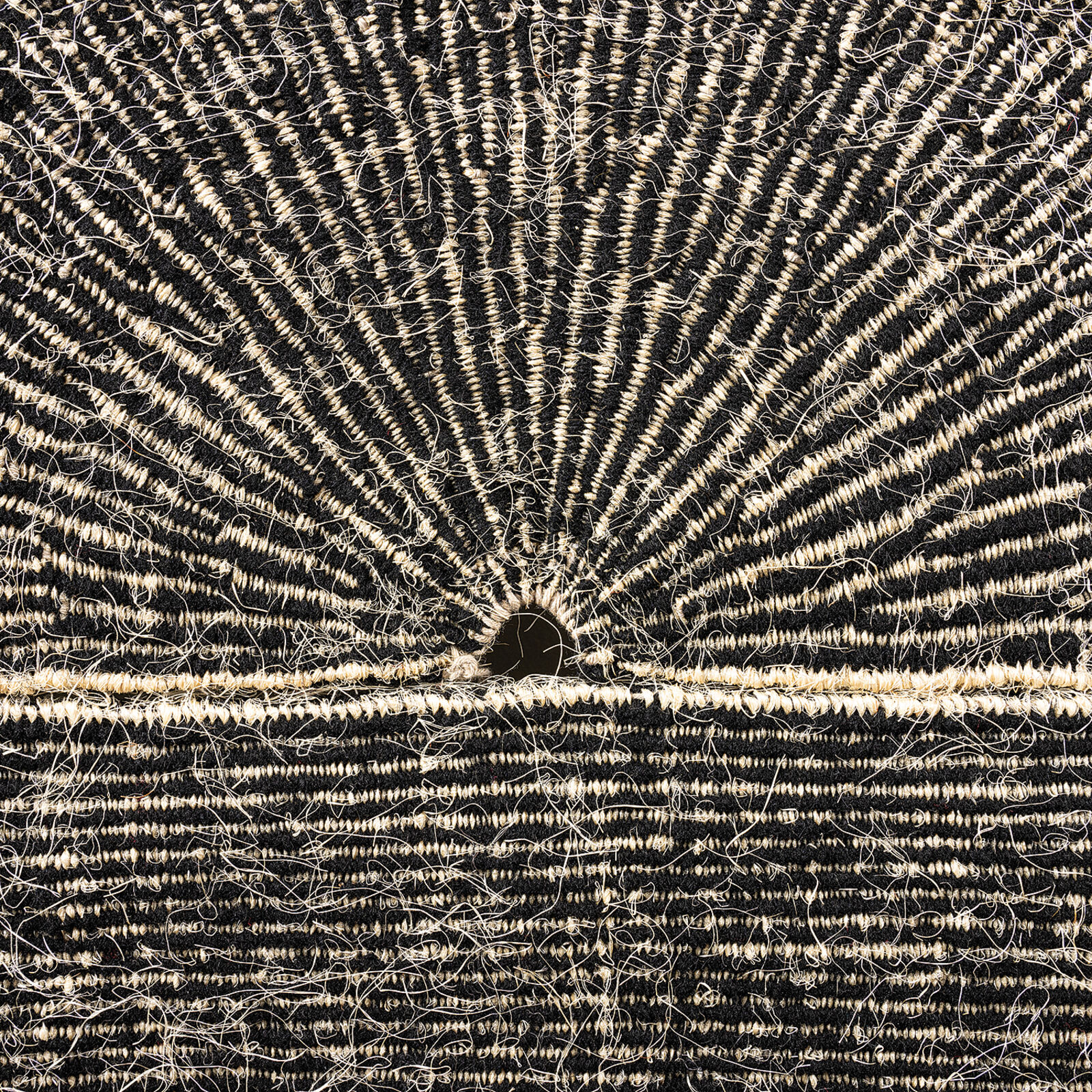 A minimalist textile artwork featuring a sunburst pattern emerging from a horizontal horizon line.