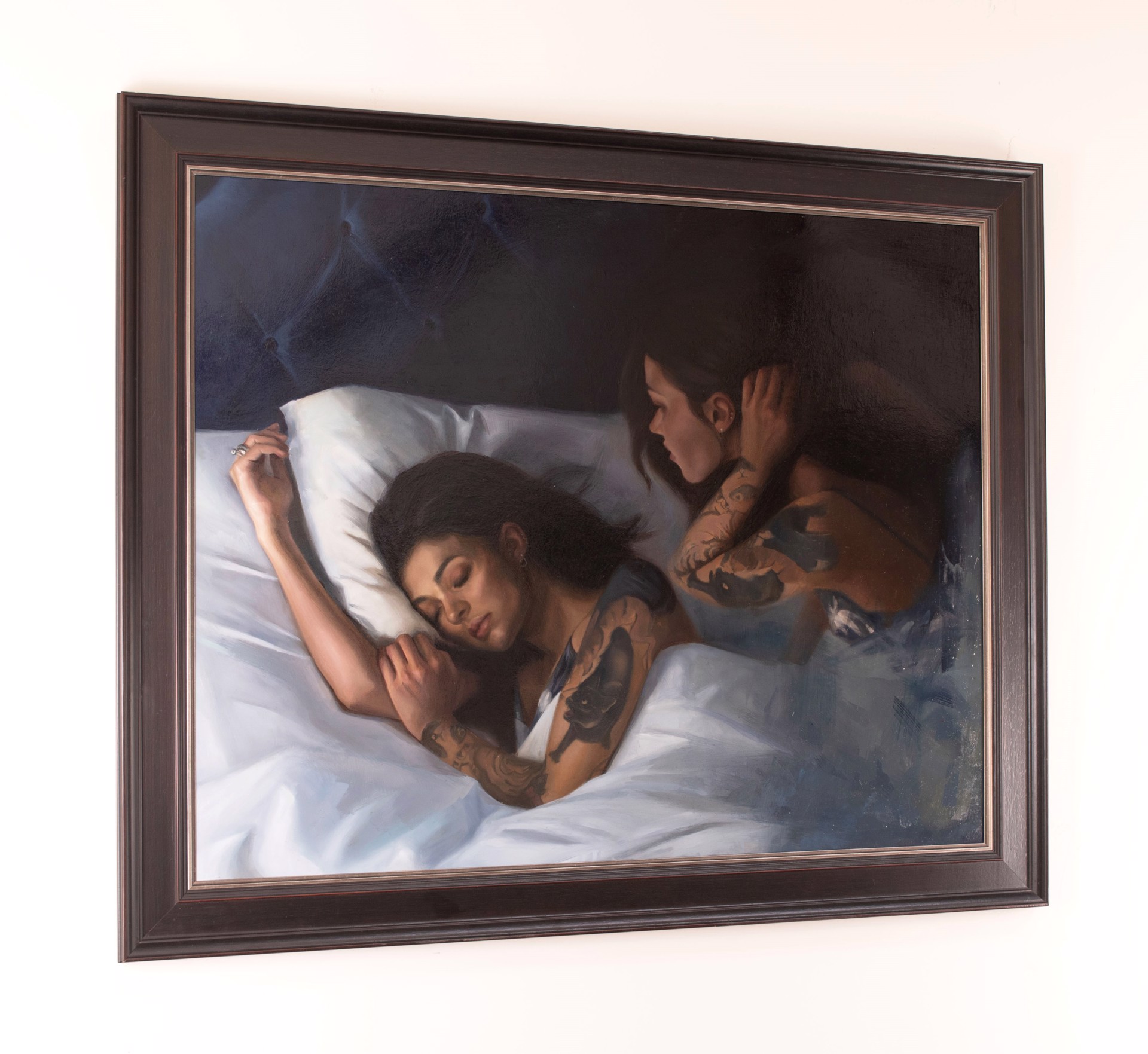 A painting of two tattooed figures in bed, one sleeping and the other awake.