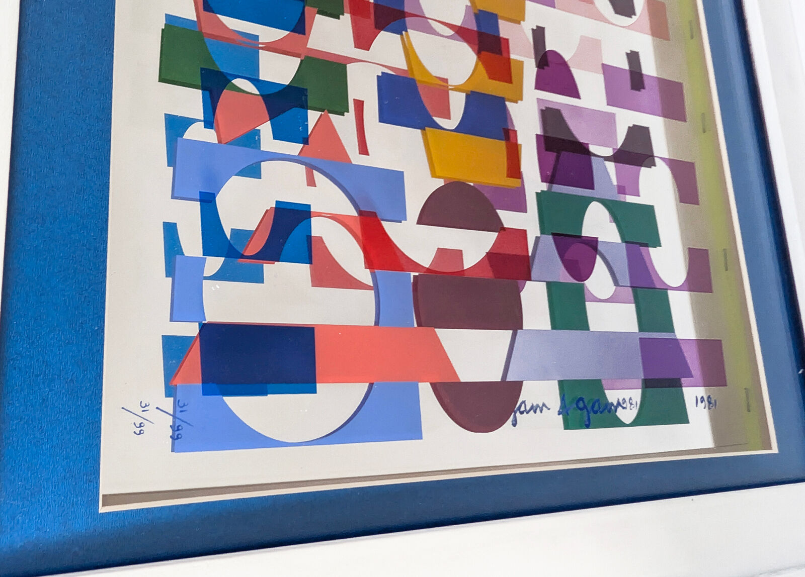 A picture of a colorful abstract painting in a white frame.