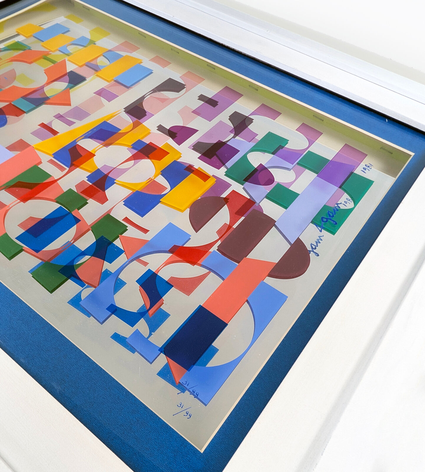A picture of a colorful abstract painting in a white frame.