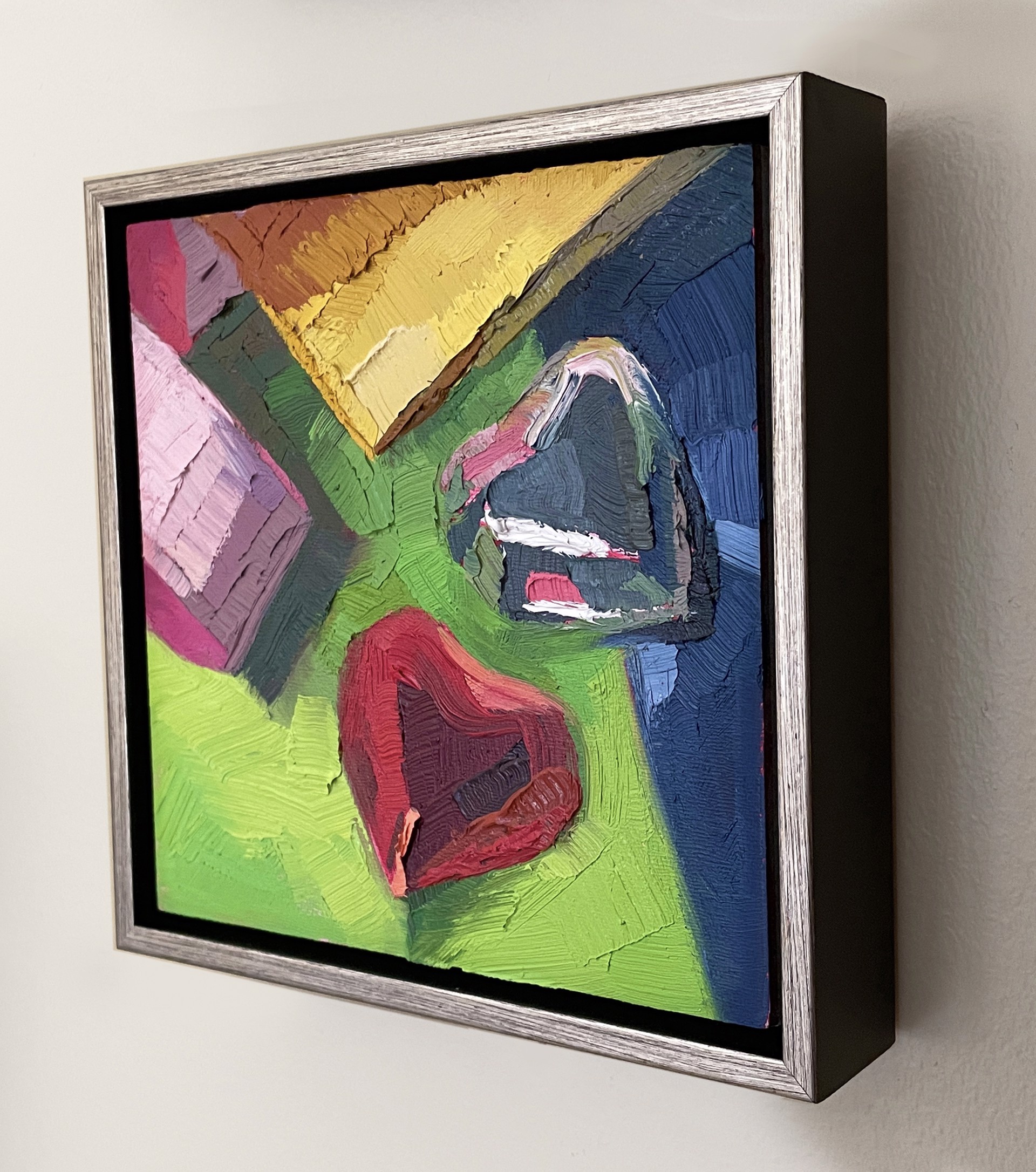 A painting of a red heart on a green background.