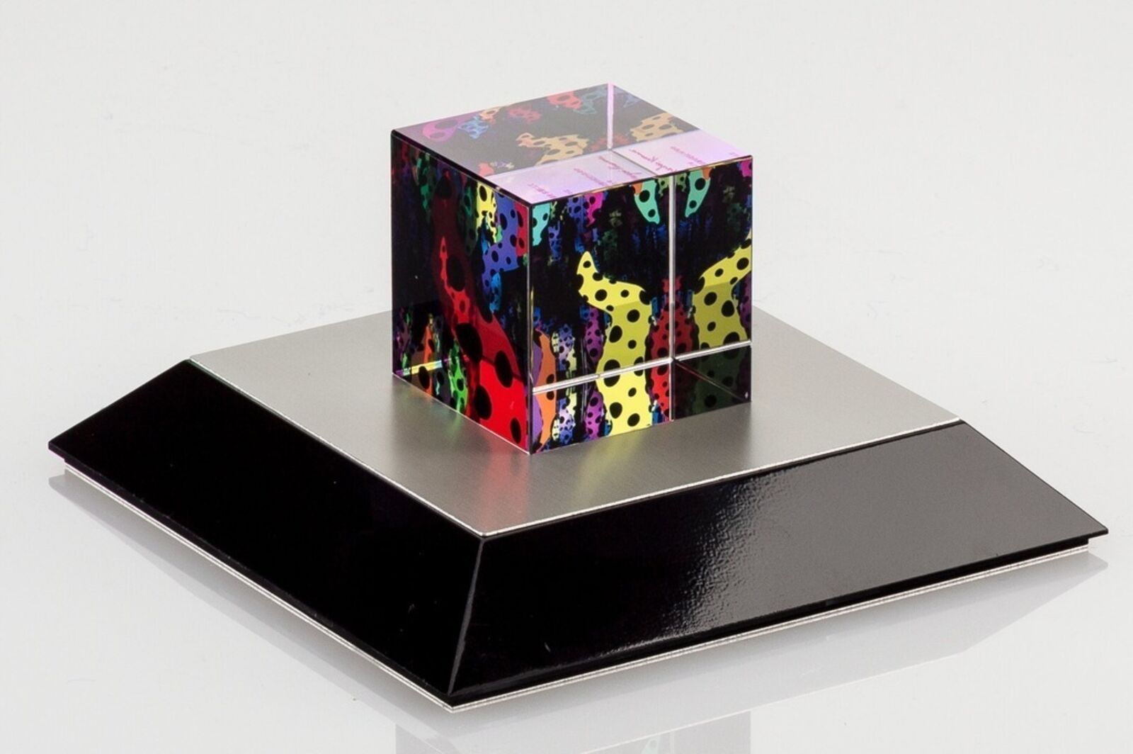 A colorful cube sitting on top of a black base.