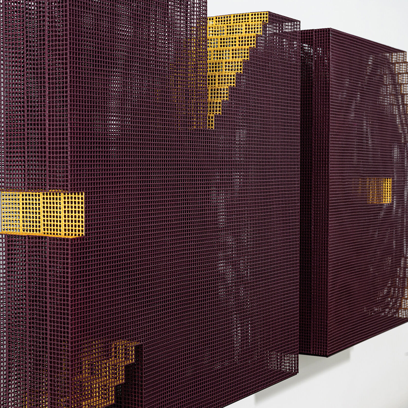 A minimalist installation featuring two pixelated, maroon-colored panels mounted on a white wall above a weathered wooden shelf.