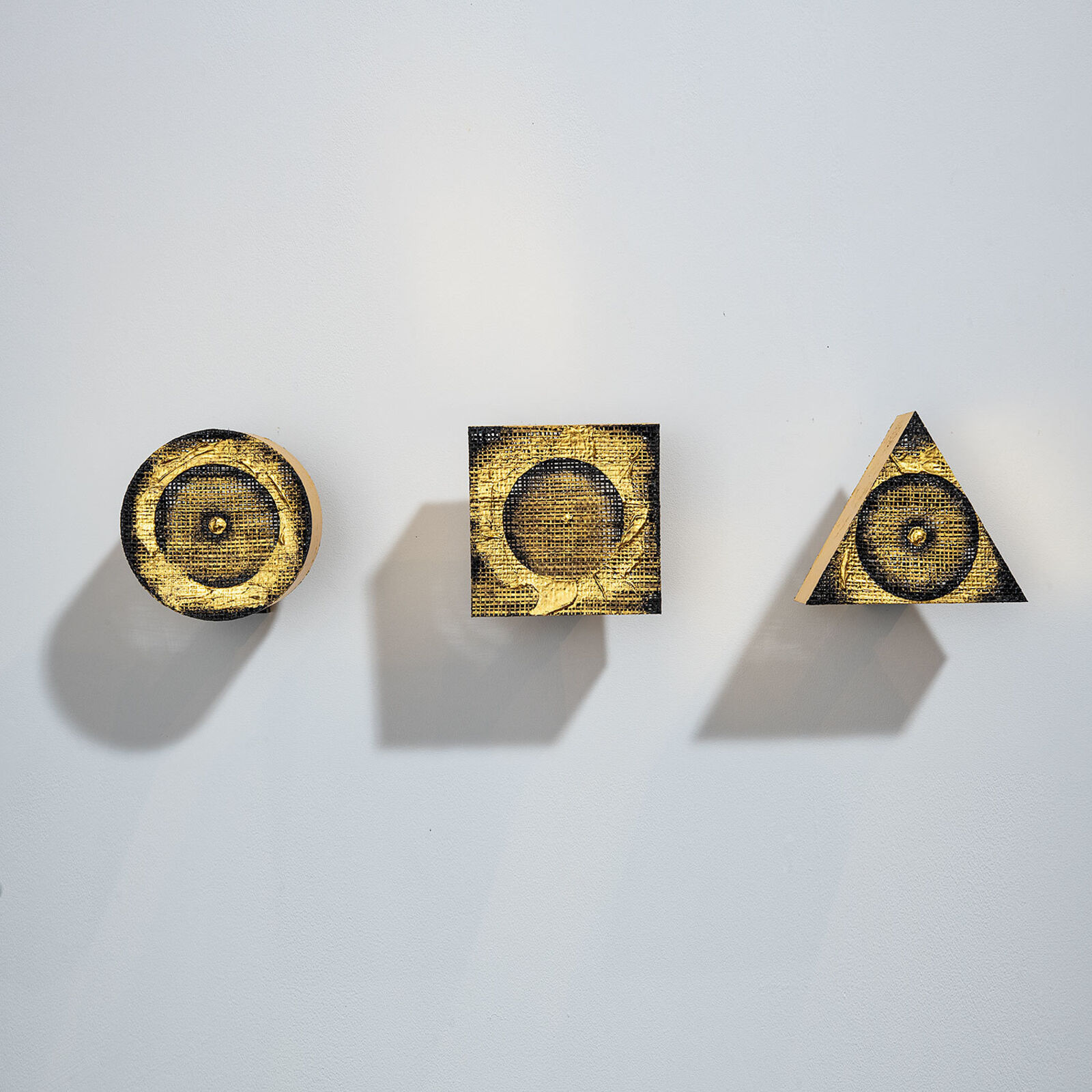 A minimalist geometric composition featuring three abstract shapes with concentric circles.