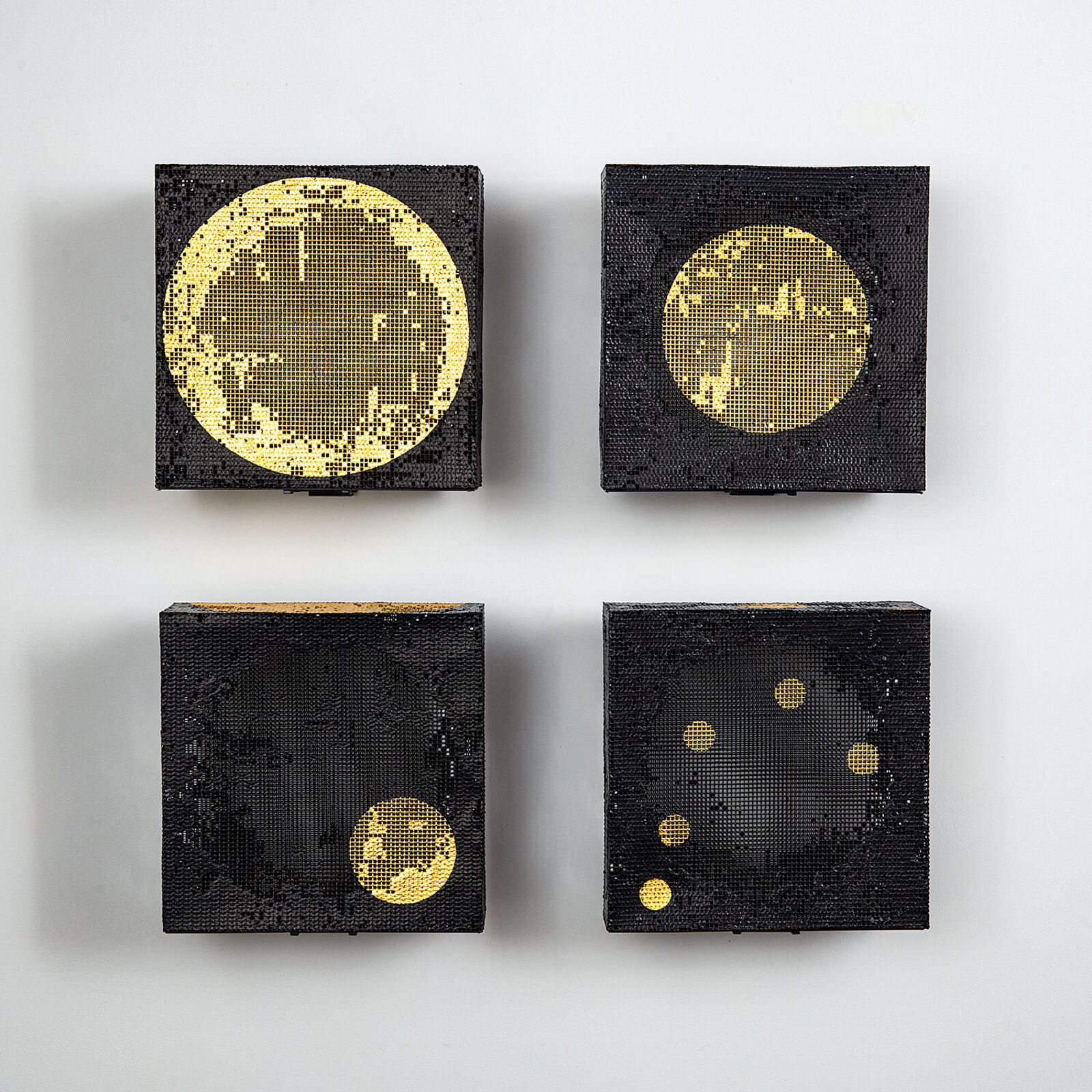 A set of four square canvases featuring pixelated celestial bodies against a minimalist interior.