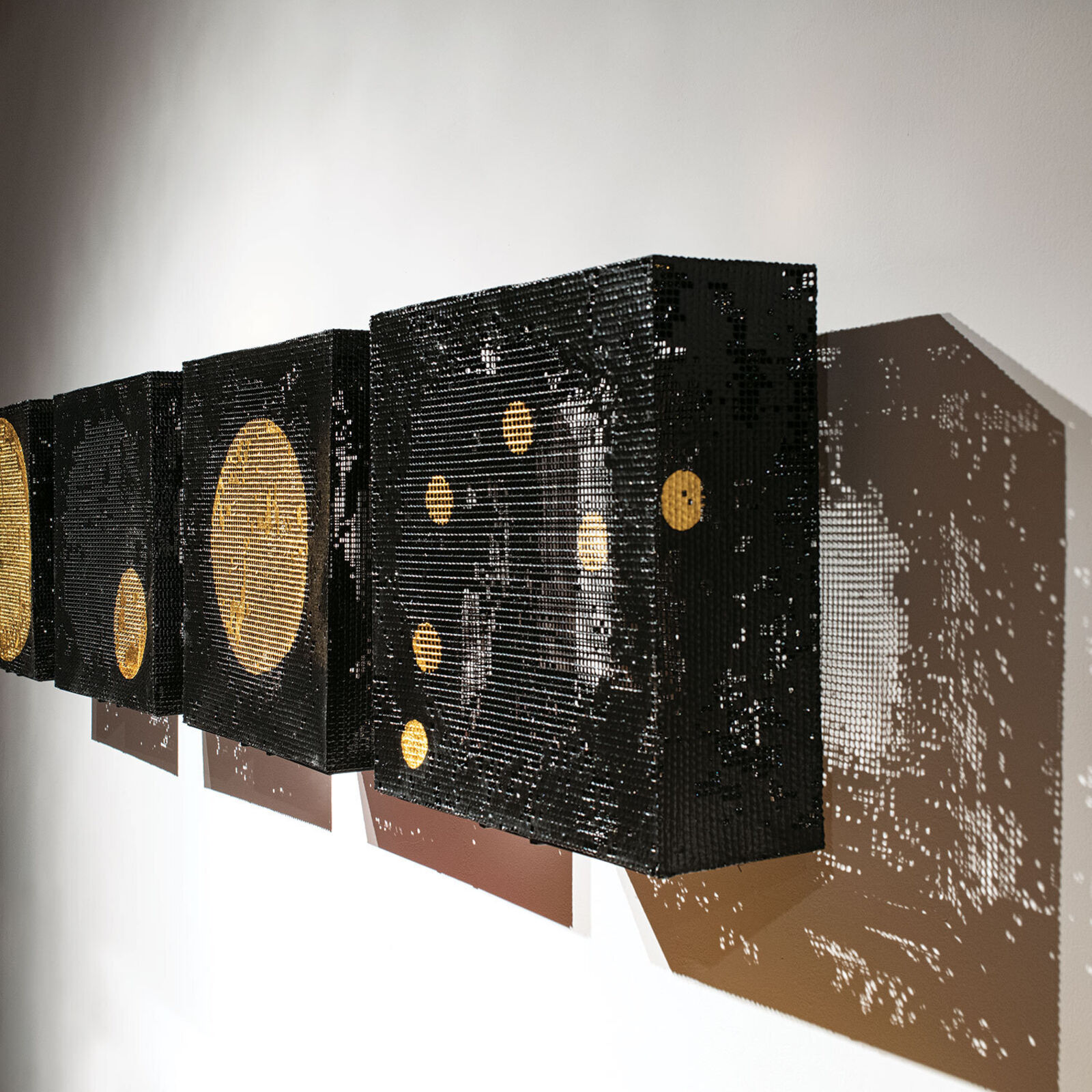 A set of four square canvases featuring pixelated celestial bodies against a minimalist interior.